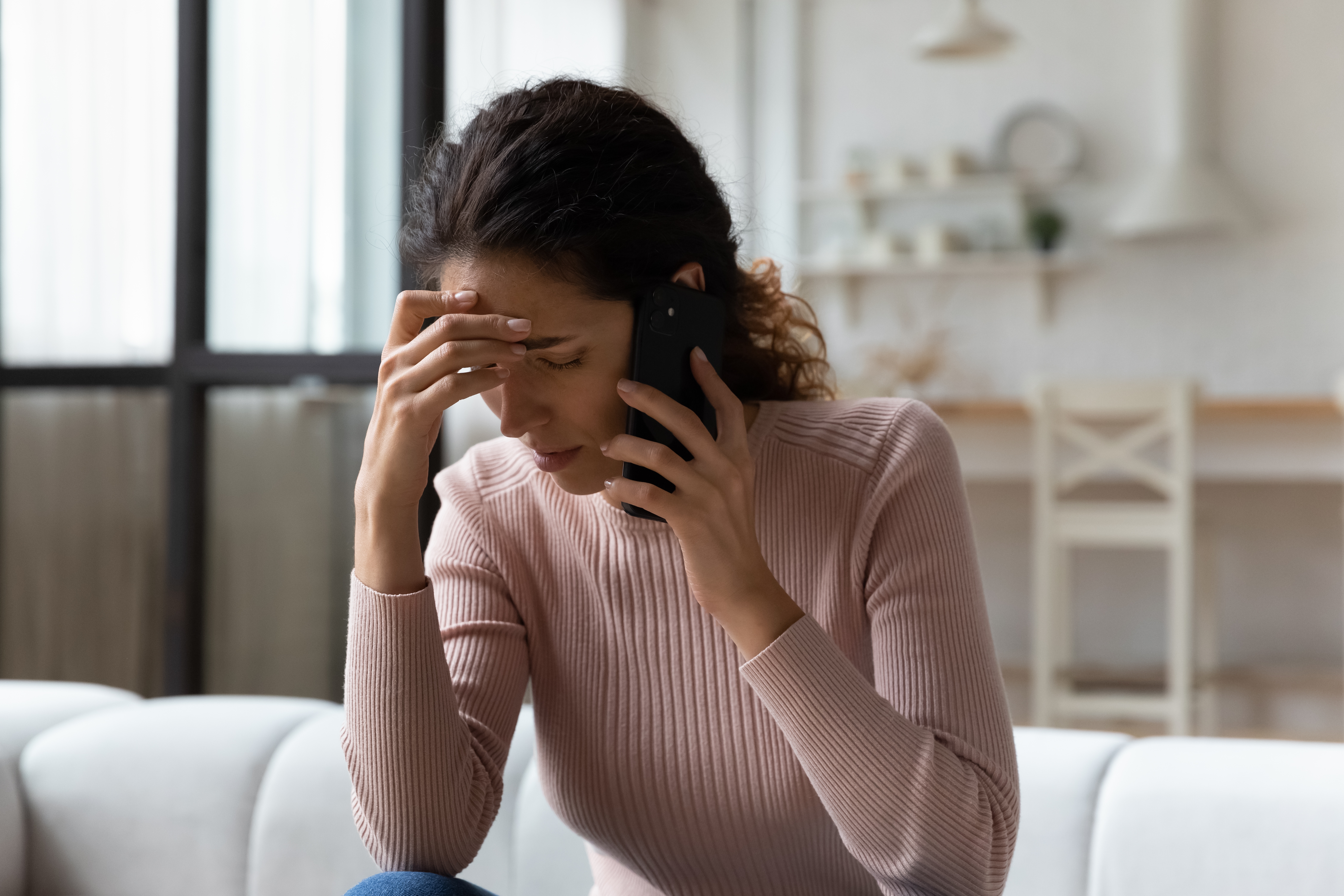 Worried woman talking on the phone | Source: Shutterstock