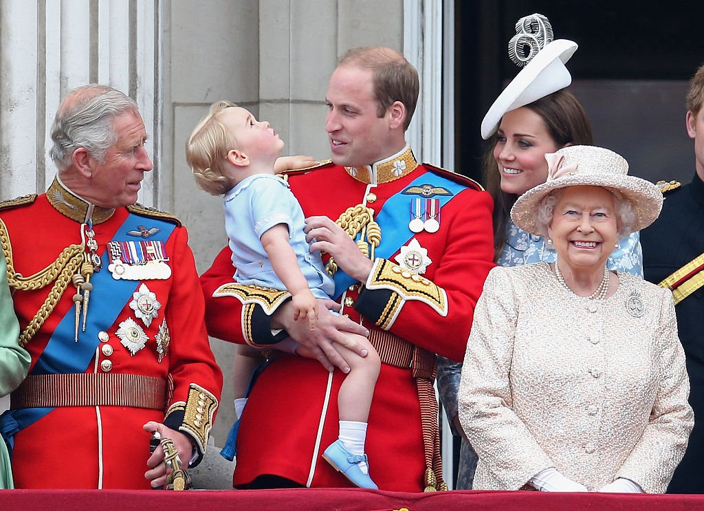 Prince George of Cambridge is held by Prince William, Duke of Cambridge and Catherine, Duchess of Cambridge, Prince Charles, Prince of Wales and Queen Elizabeth II look out on the balcony of uckingham Palace during the Trooping the Colour on June 13, 2015 in London, England. | Photo: GettyImages