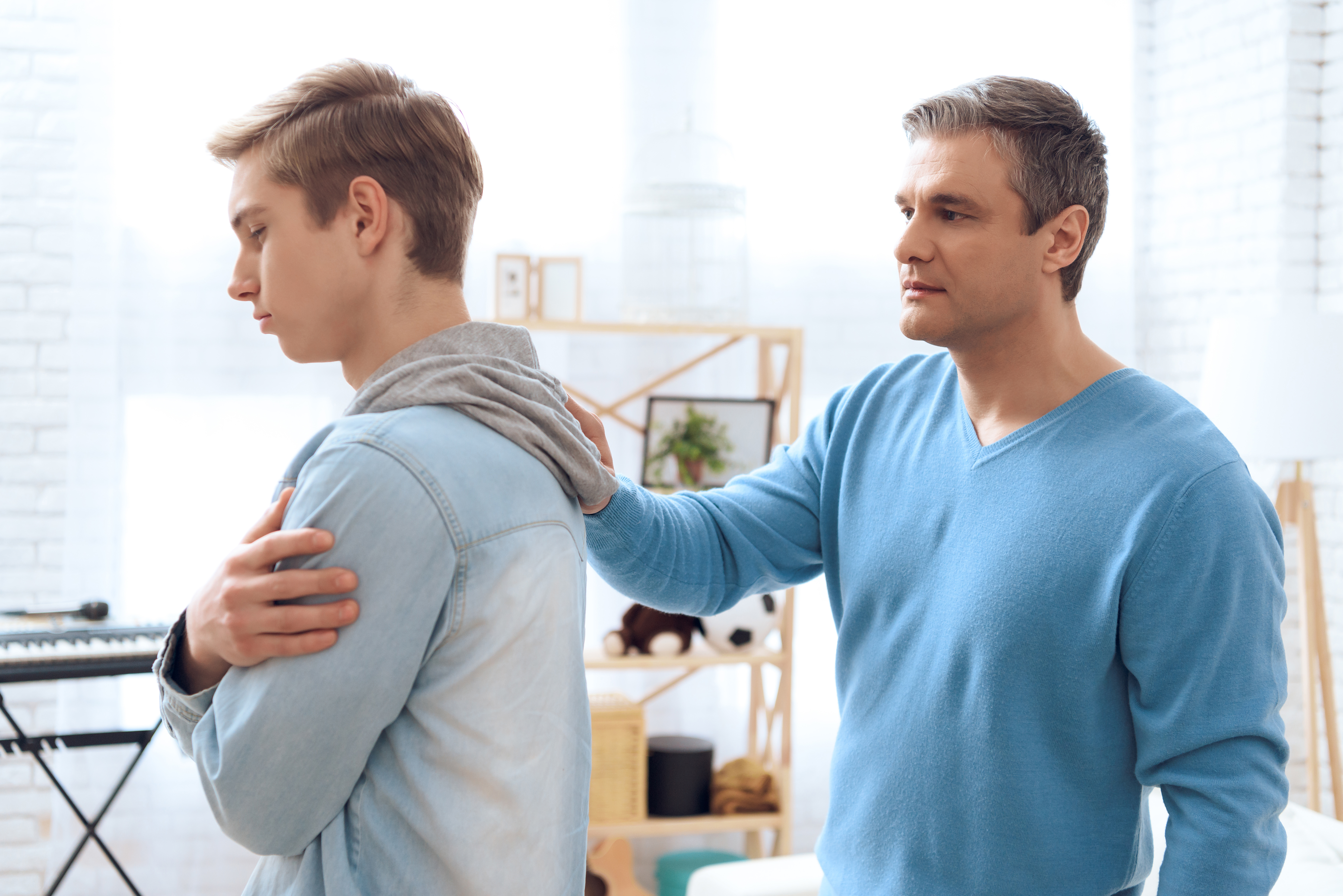 Father tries to talk to his son, but problem teenager is deep in his own thoughts. | Source: Shutterstock