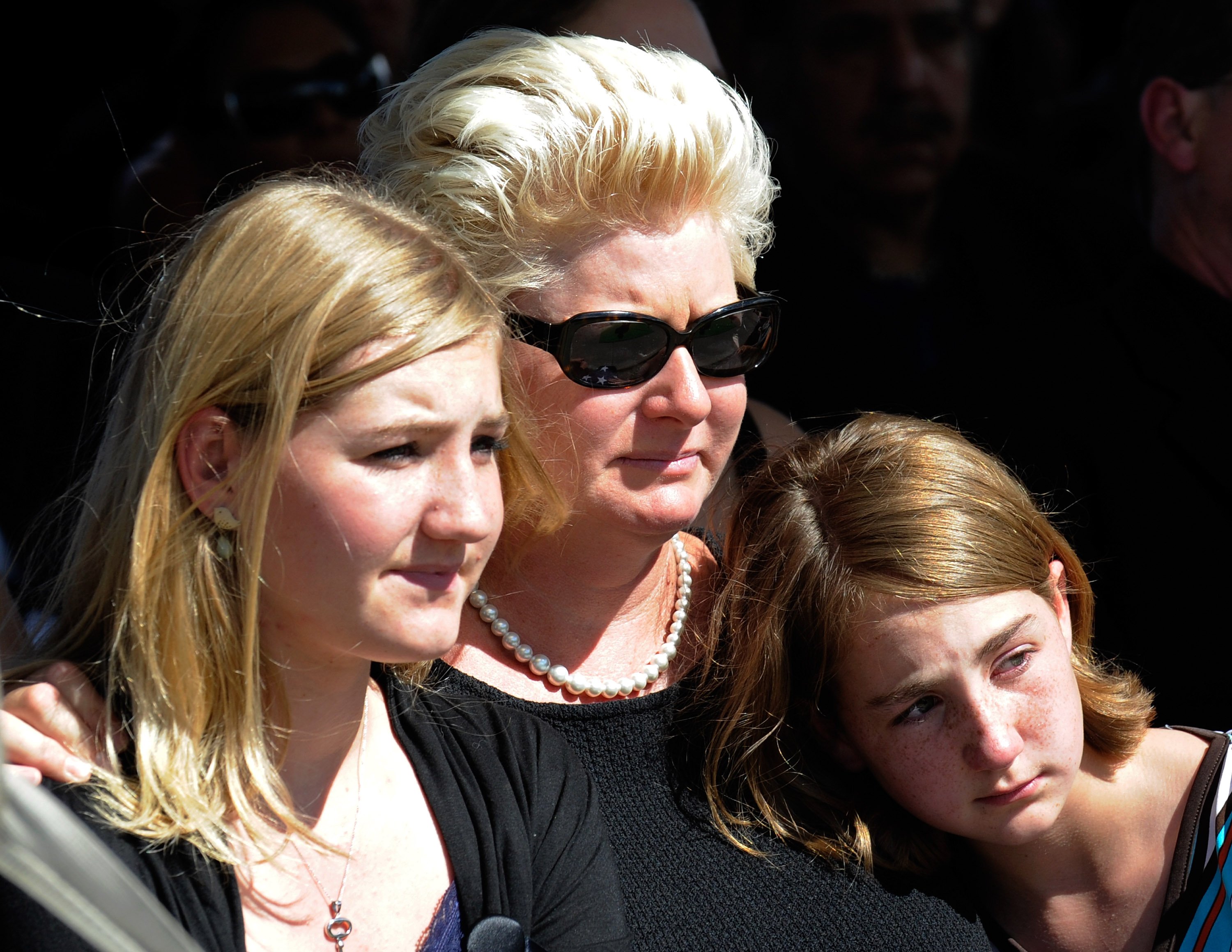 Jill Vandenberg comforting young mourners during the funeral for her late husband Tony Curtis at Palm Mortuary & Cemetery on October 4, 2010, in Henderson, Nevada | Source: Getty Images