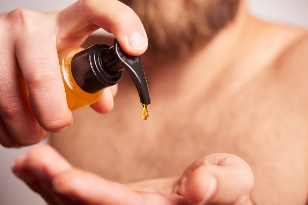 Un homme utilisant de l'huile pour sa barbe | Photo : Shutterstock