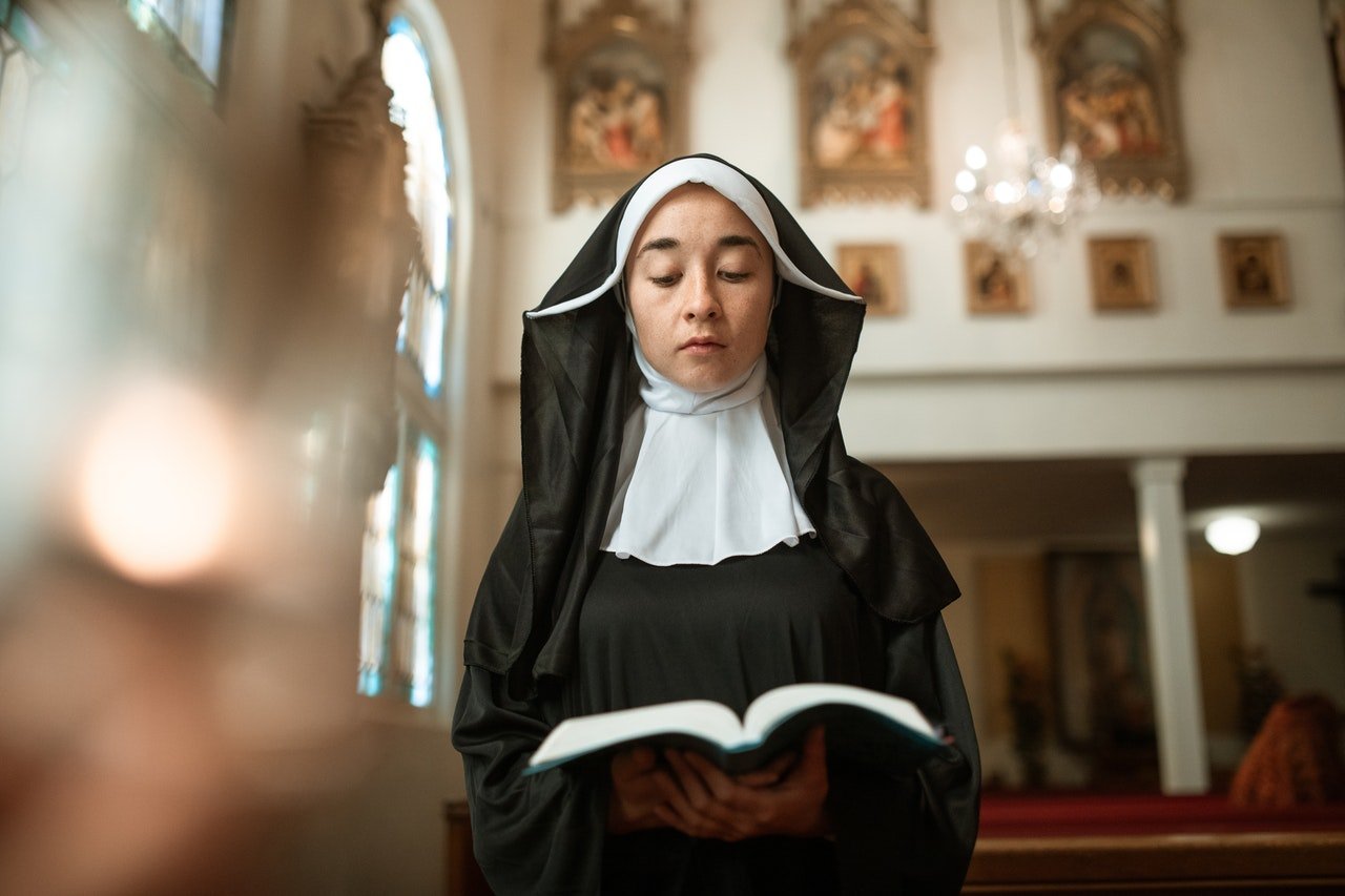 Photo of a nun reading a book | Photo: Pexels