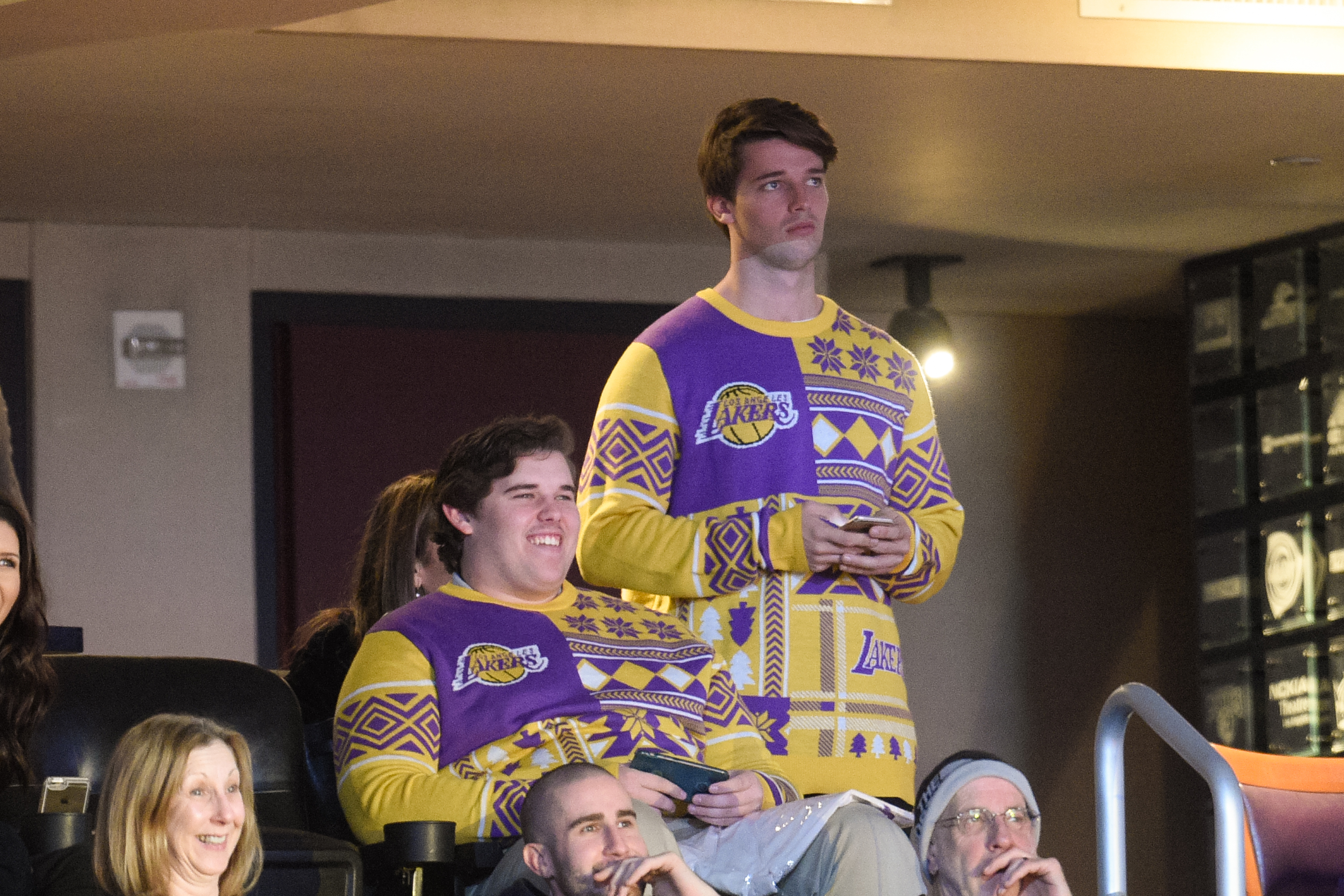 Christopher watches the Lakers game with his brother Patrick at the Staples Center in Los Angeles in December 2015. Dressed in a bold purple and yellow Lakers-themed holiday sweater, Christopher is seen seated and smiling, his hair neatly combed and his frame notably fuller at the time.