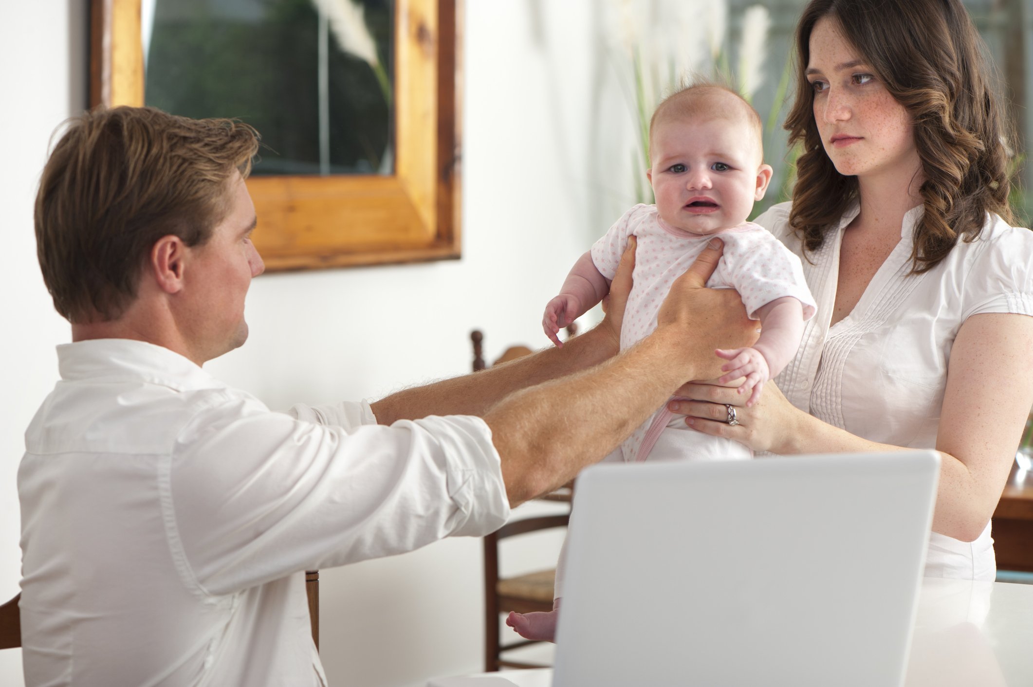 Frustriert Vater gibt das weinende Baby seiner Frau I Quelle: Getty Images