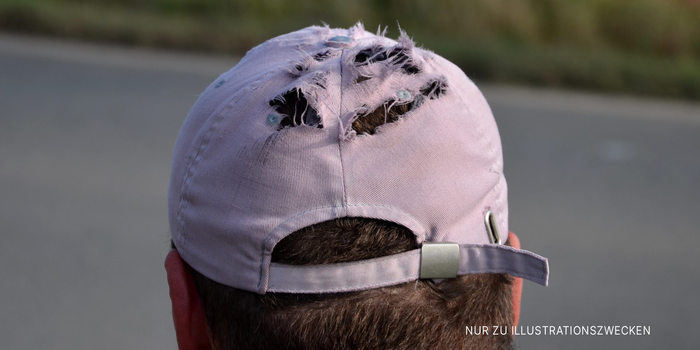 Zerrissene Baseballkappe auf dem Kopf eines Mannes | Quelle: Shutterstock