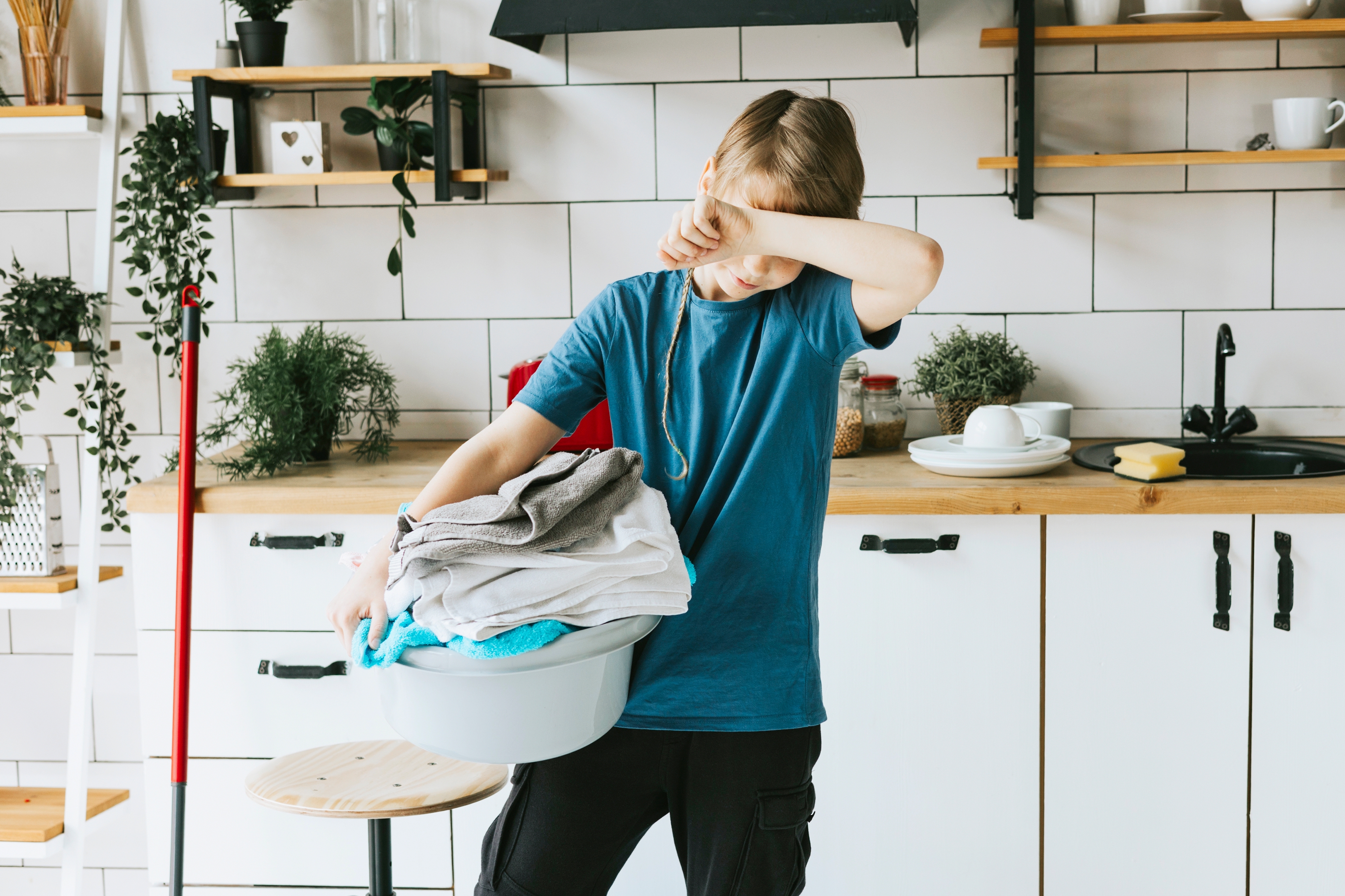 Young boy carrying a laundry basket | Source: Shutterstock