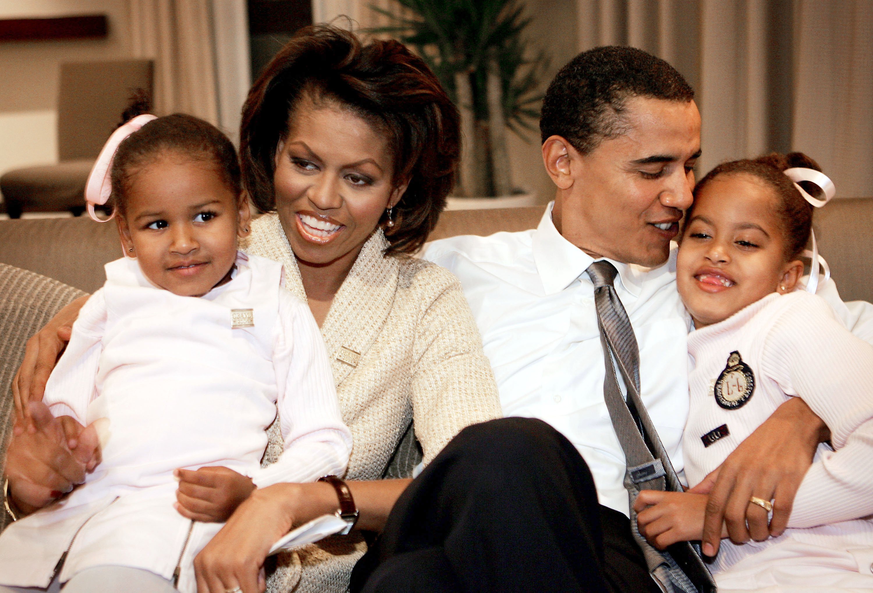 Barack Obama sits with his wife Michelle and daughters Sasha and Malia in a hotel room as they wait for election returns to come in November 2, 2004, in Chicago, Illinois. | Source: Getty Images