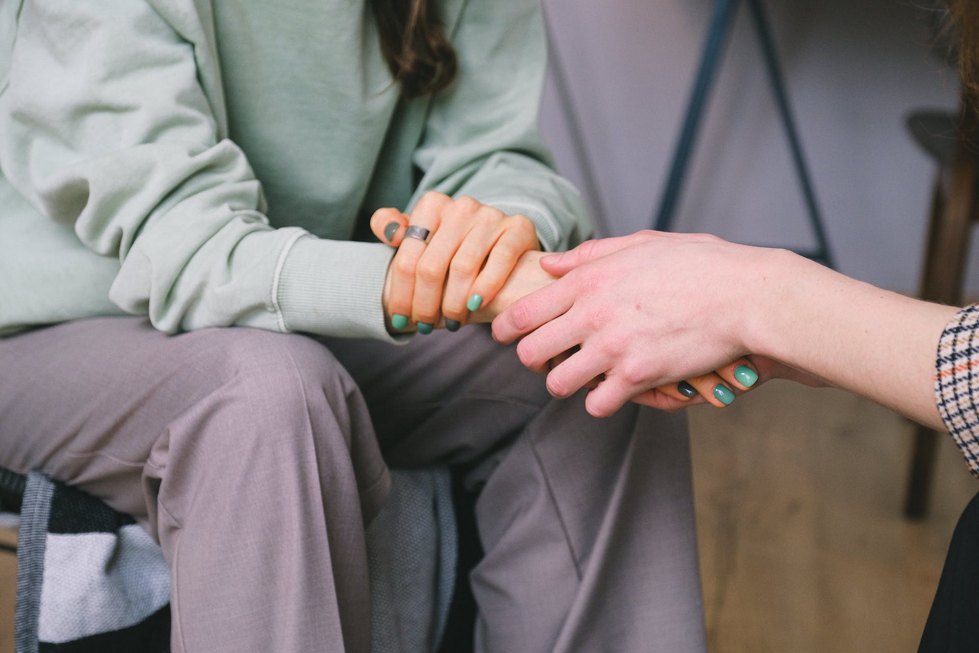 Two people holding hands in support | Source: Pexels