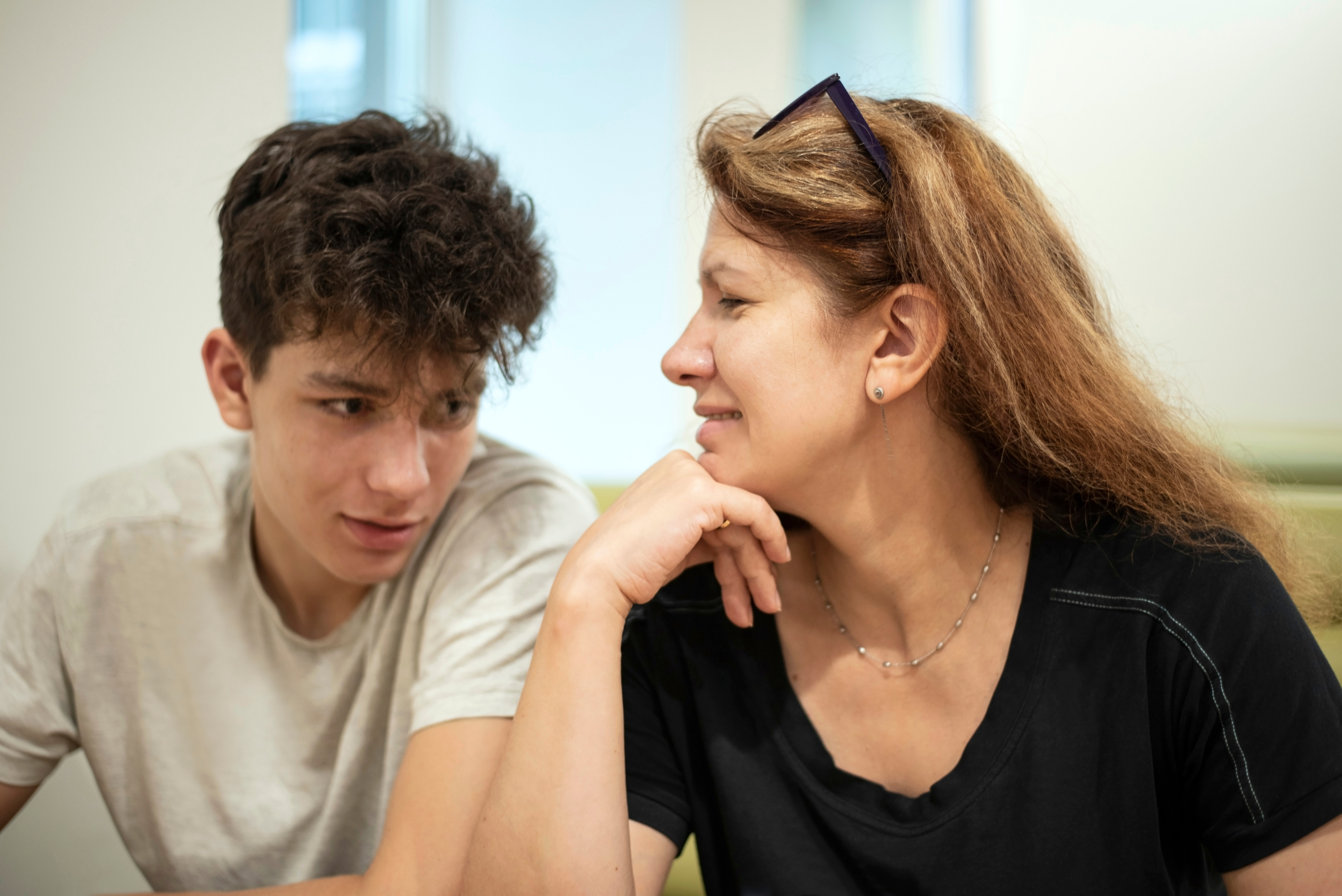 A middle aged woman and a teenage boy talking | Source: Shutterstock