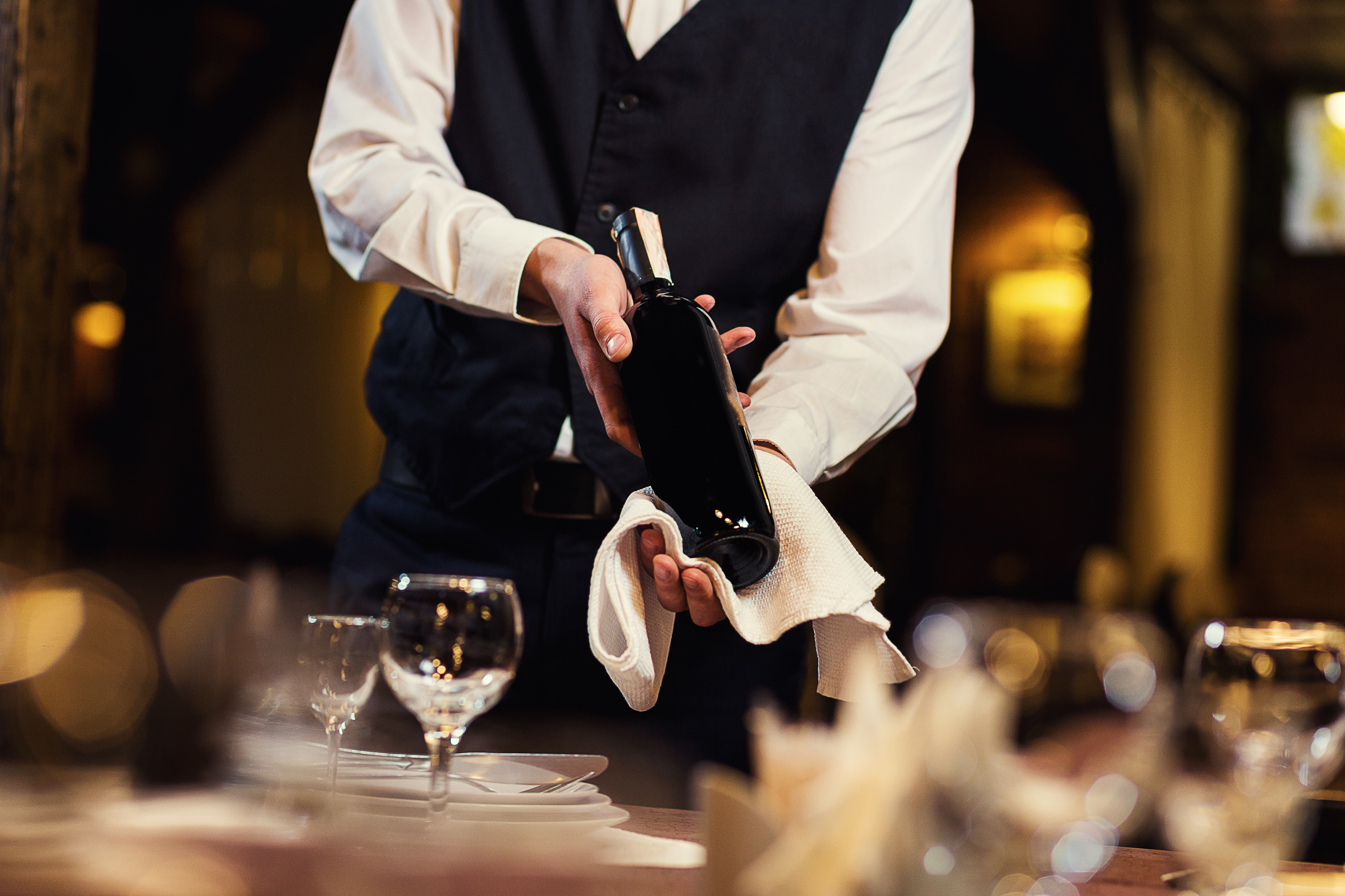 The waiter in uniform with a white towel. | Source: Shutterstock