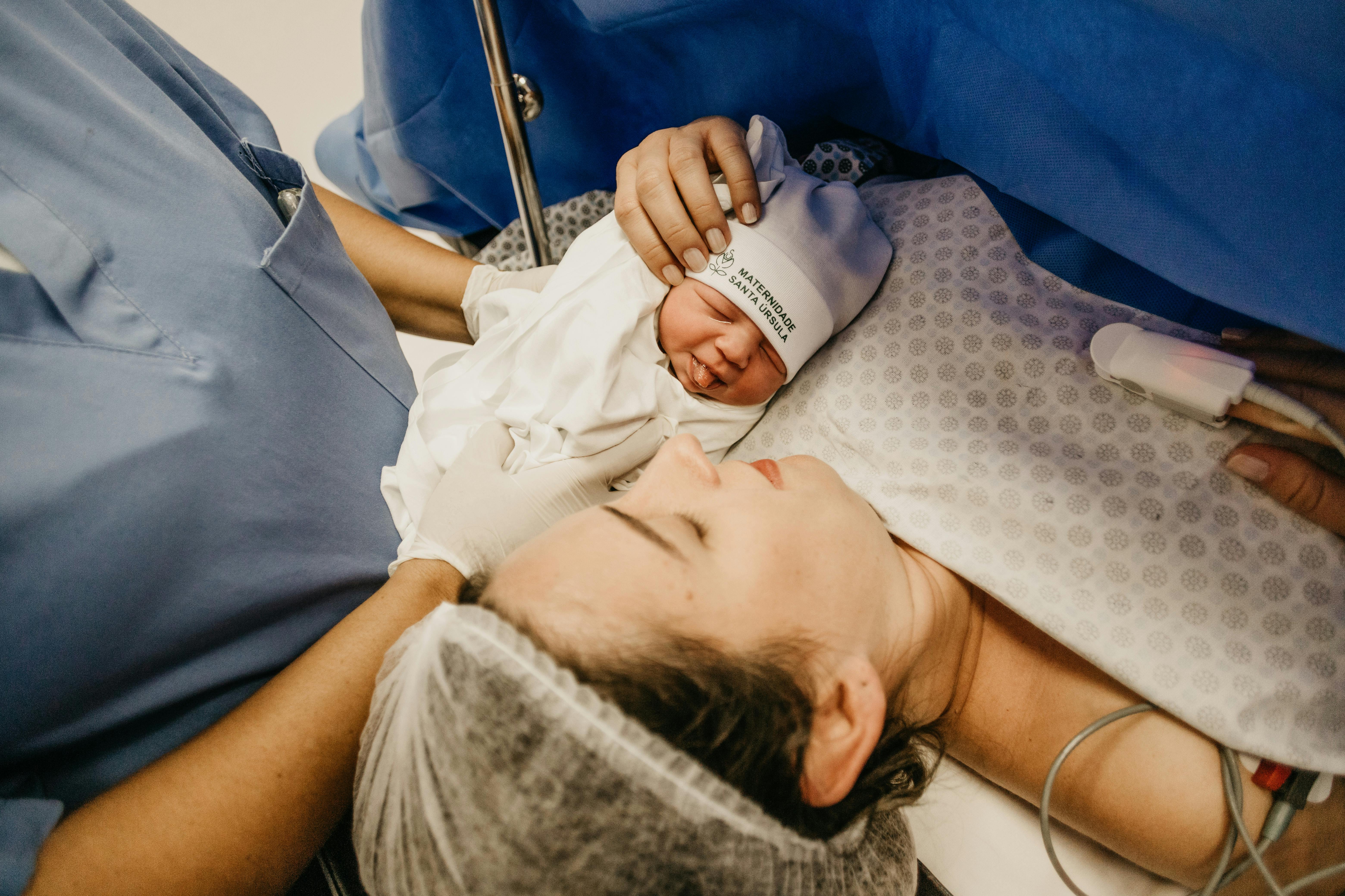 A man holding a newborn baby | Source: Pexels