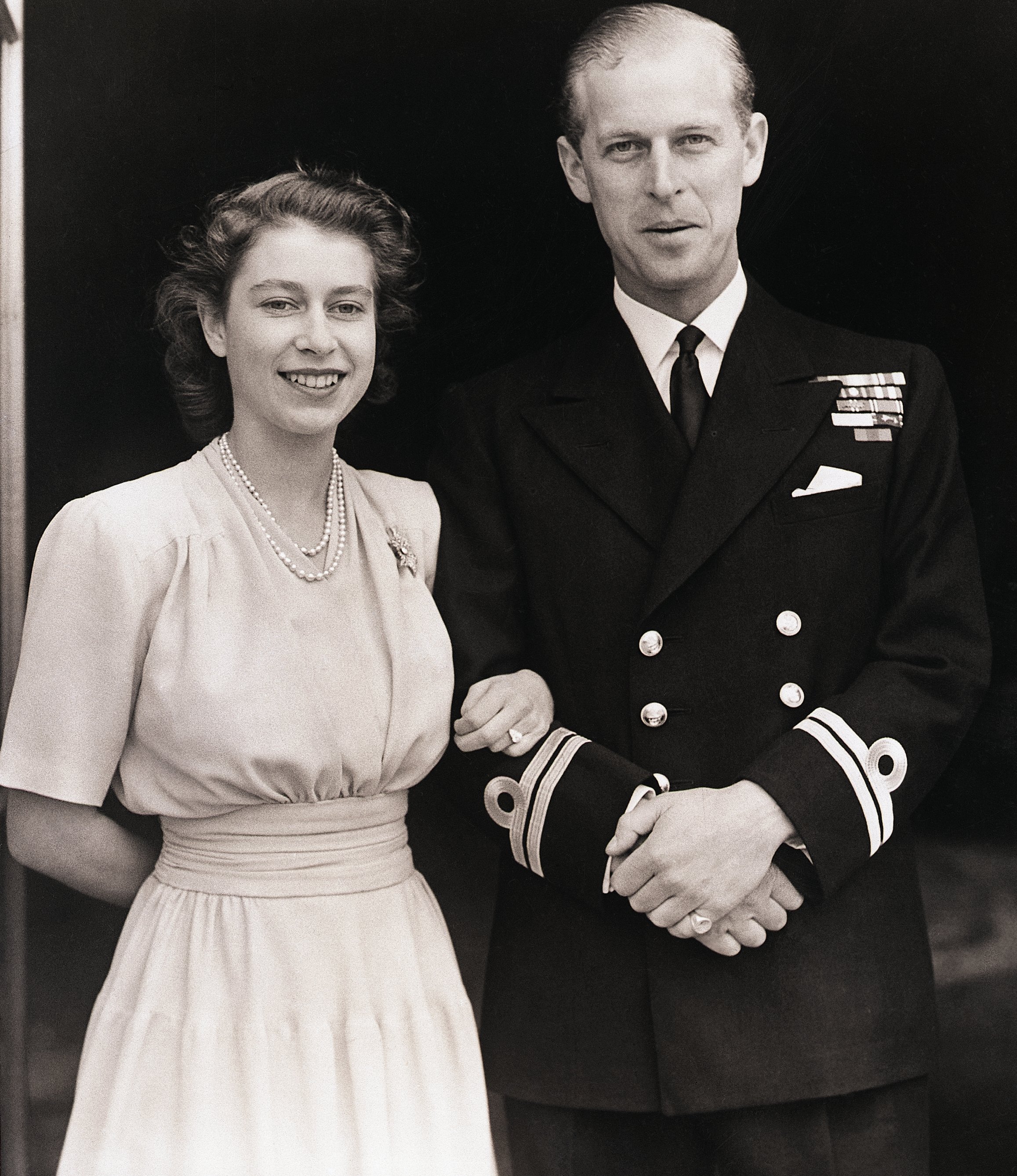 Queen Elizabeth II and Prince Philip shown at Buckingham Palace. The Princess wears a three-diamond ring on her engagement finger, symbolic of her betrothal. | Source: Getty Images