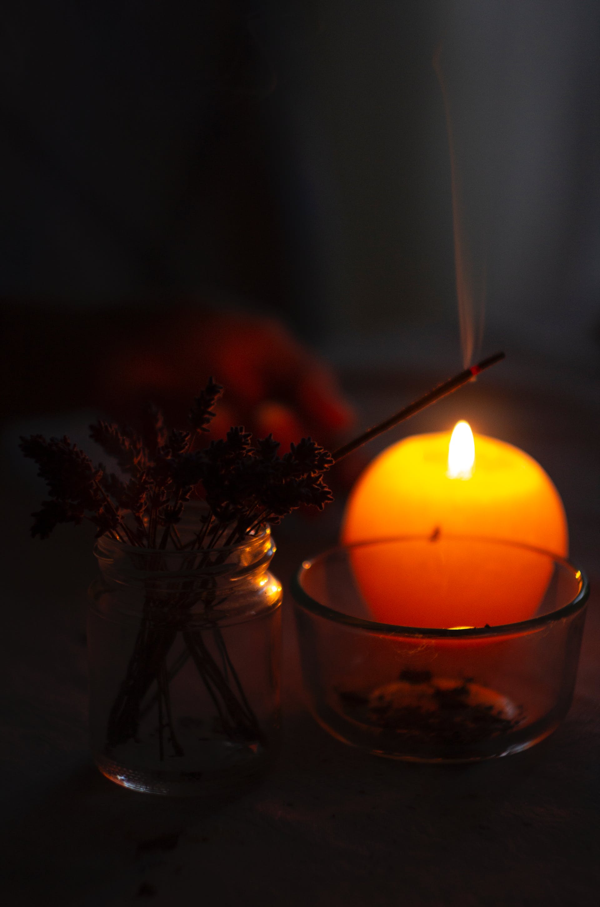 Some lit incense and a lit candle | Source: Pexels