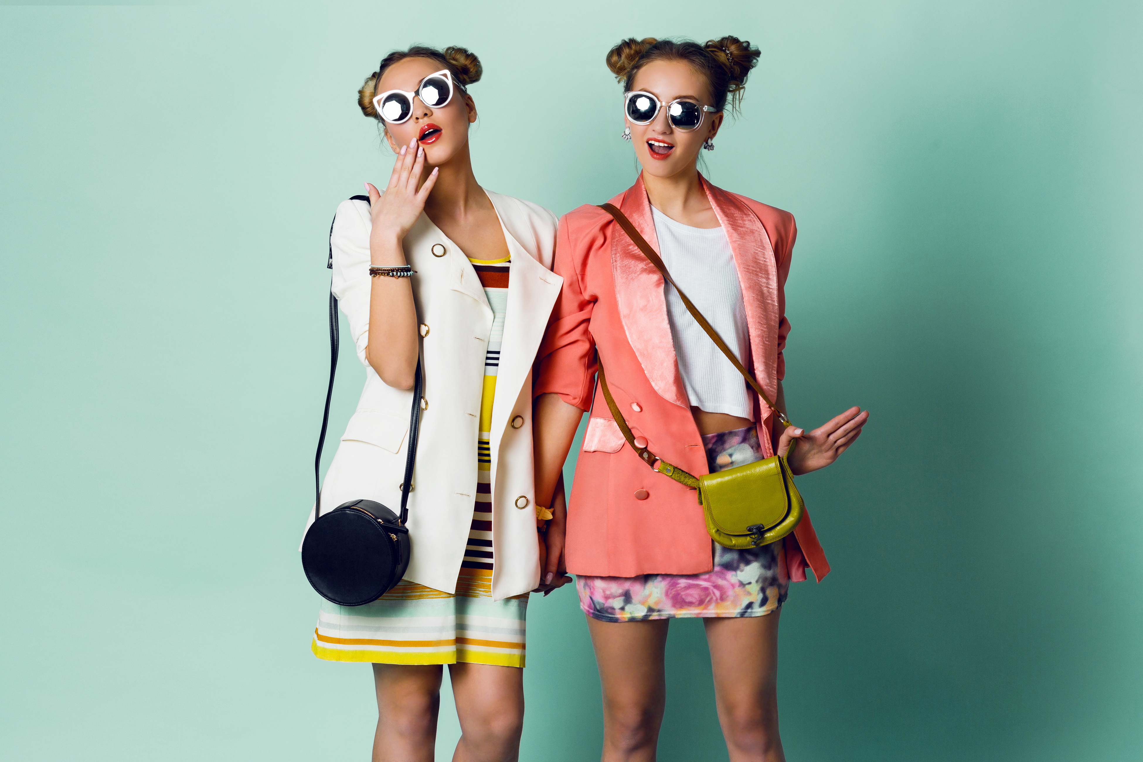 Two sisters with horns hairstyles wearing stylish jackets and funky sunglasses | Source: Shutterstock
