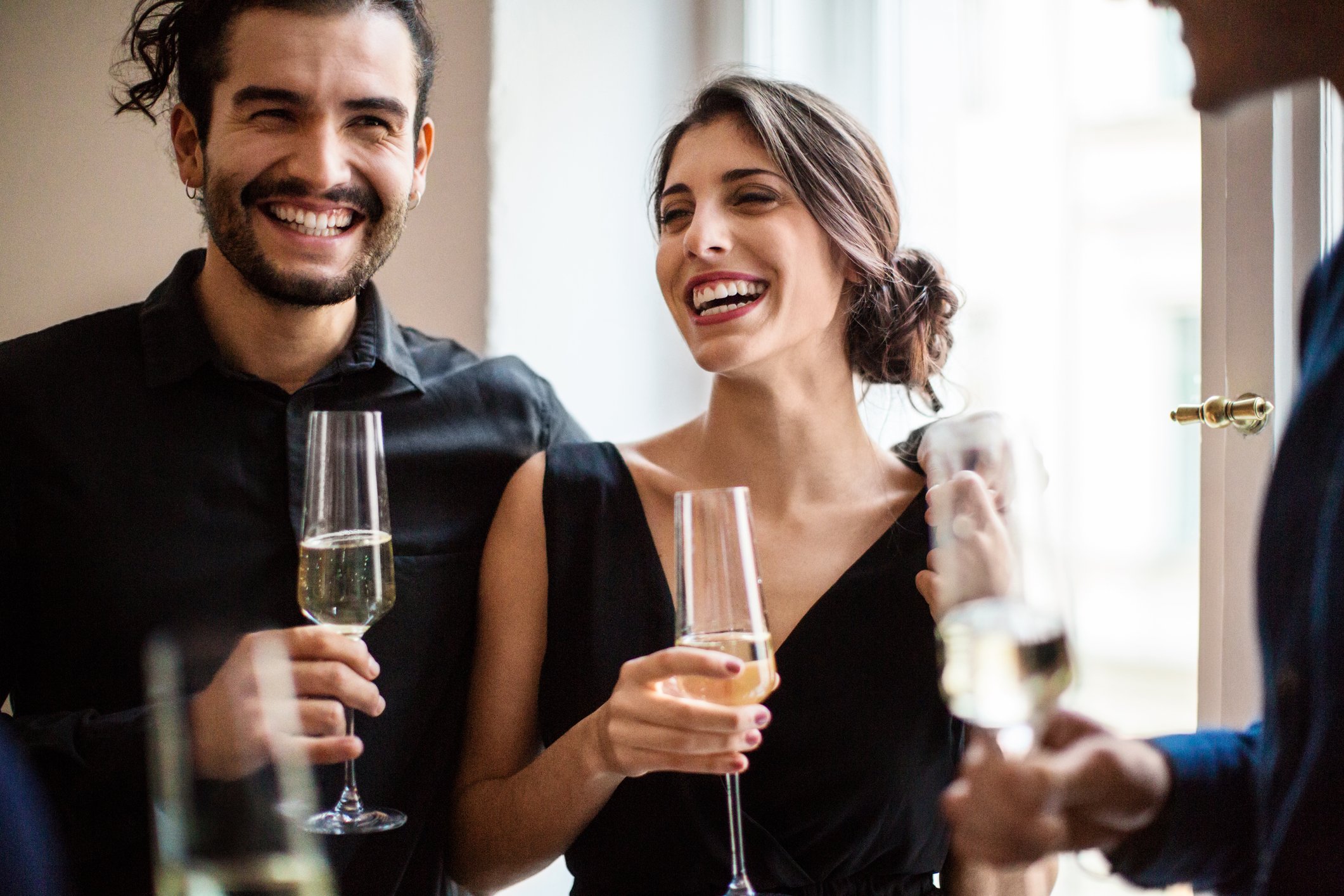 Happy man and woman holding champagne flutes during an event | Photo: Getty Images