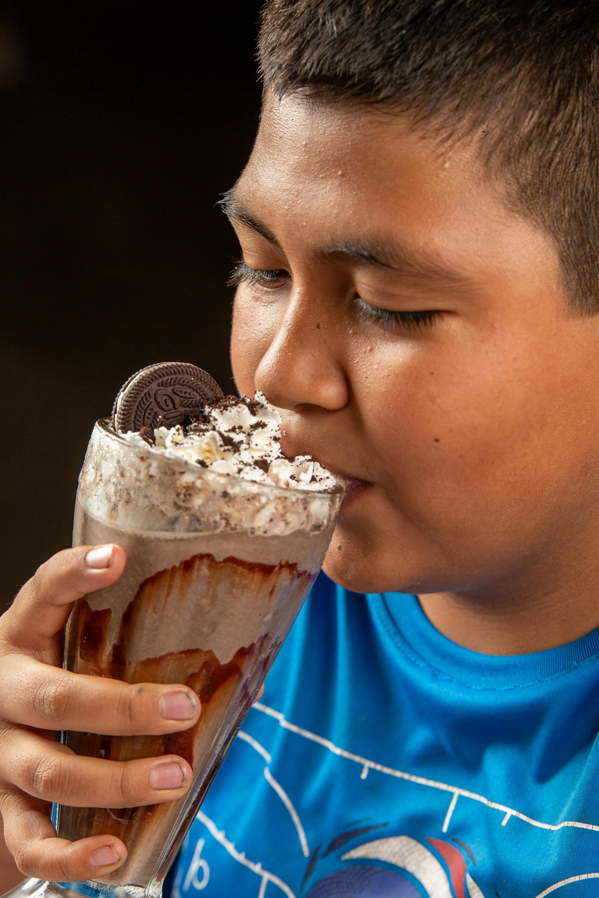 A boy drinking Oreo milkshake | Source: Pexels