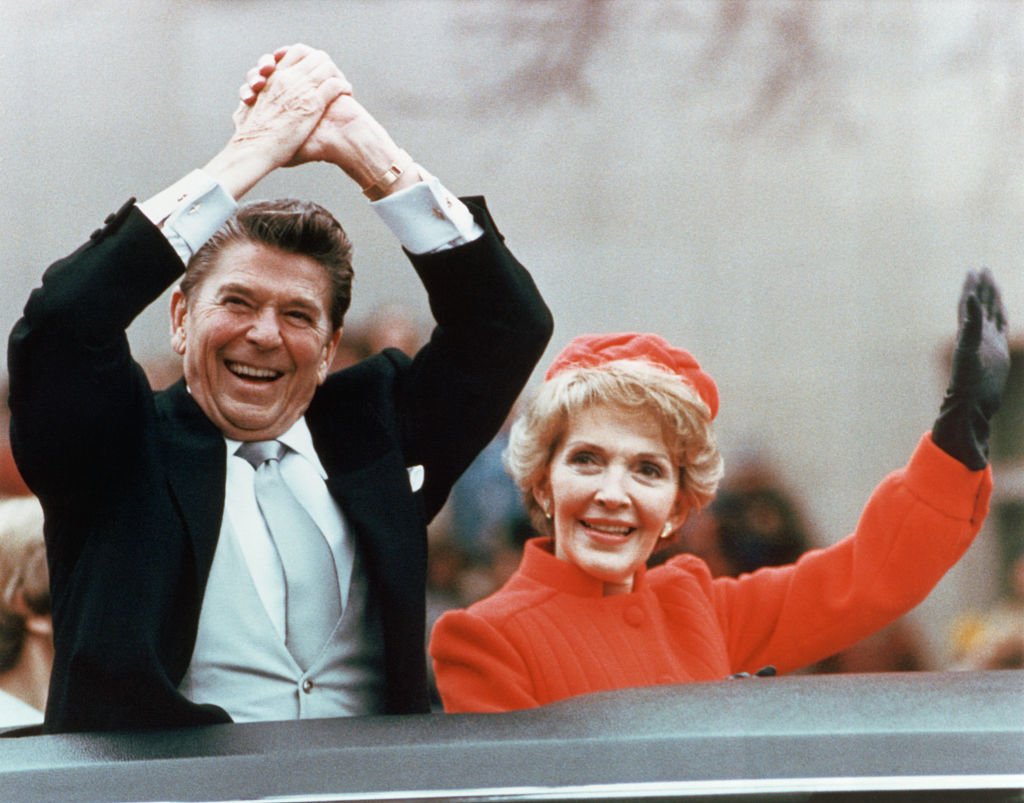 Ronald and Nancy Reagan waving and clasping hands in victory at Reagan's first inauguration, January 20, 1981. | Source: Getty Images