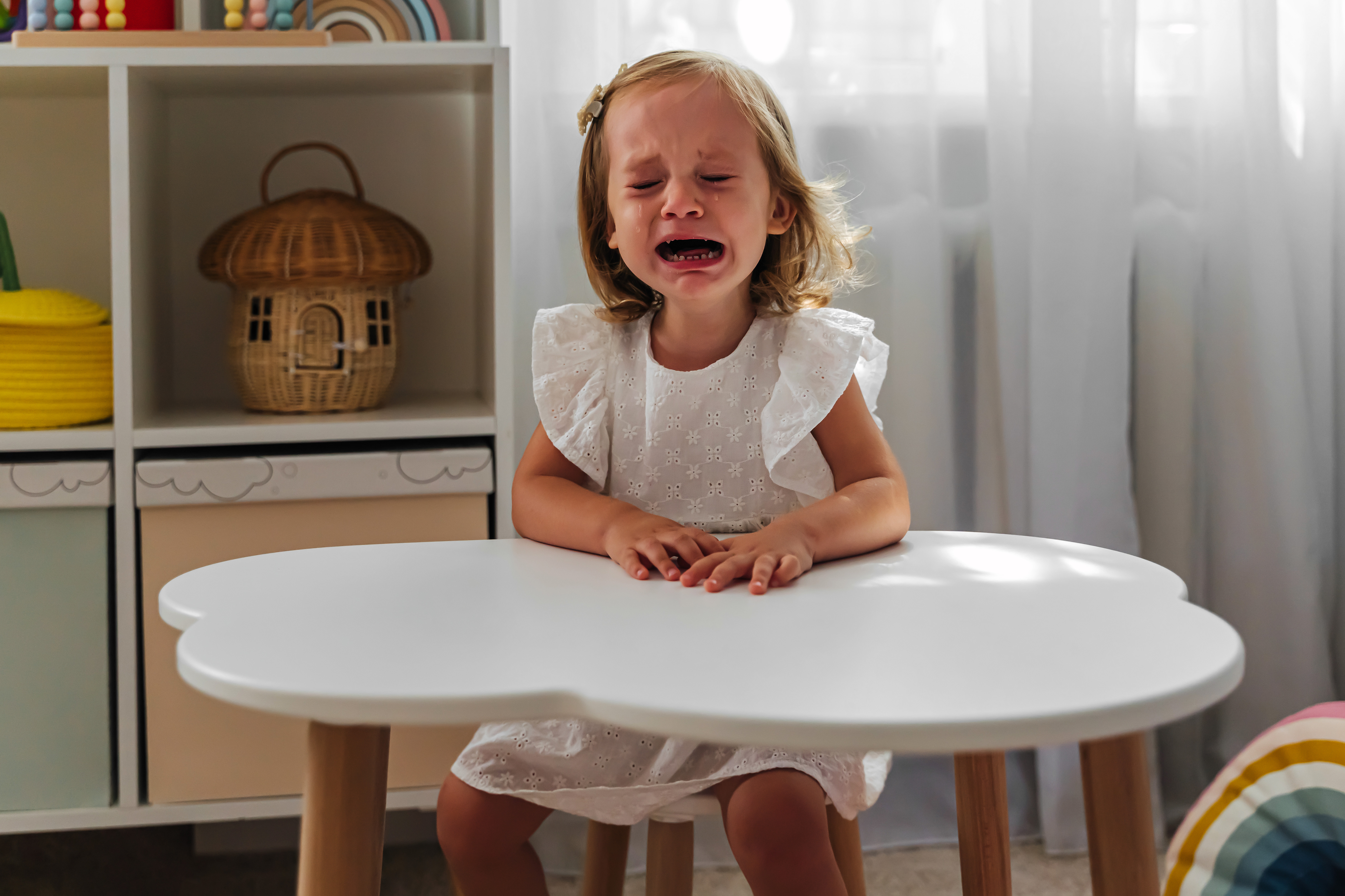 A little girl crying while sitting at the table in her class | Source: Getty Images