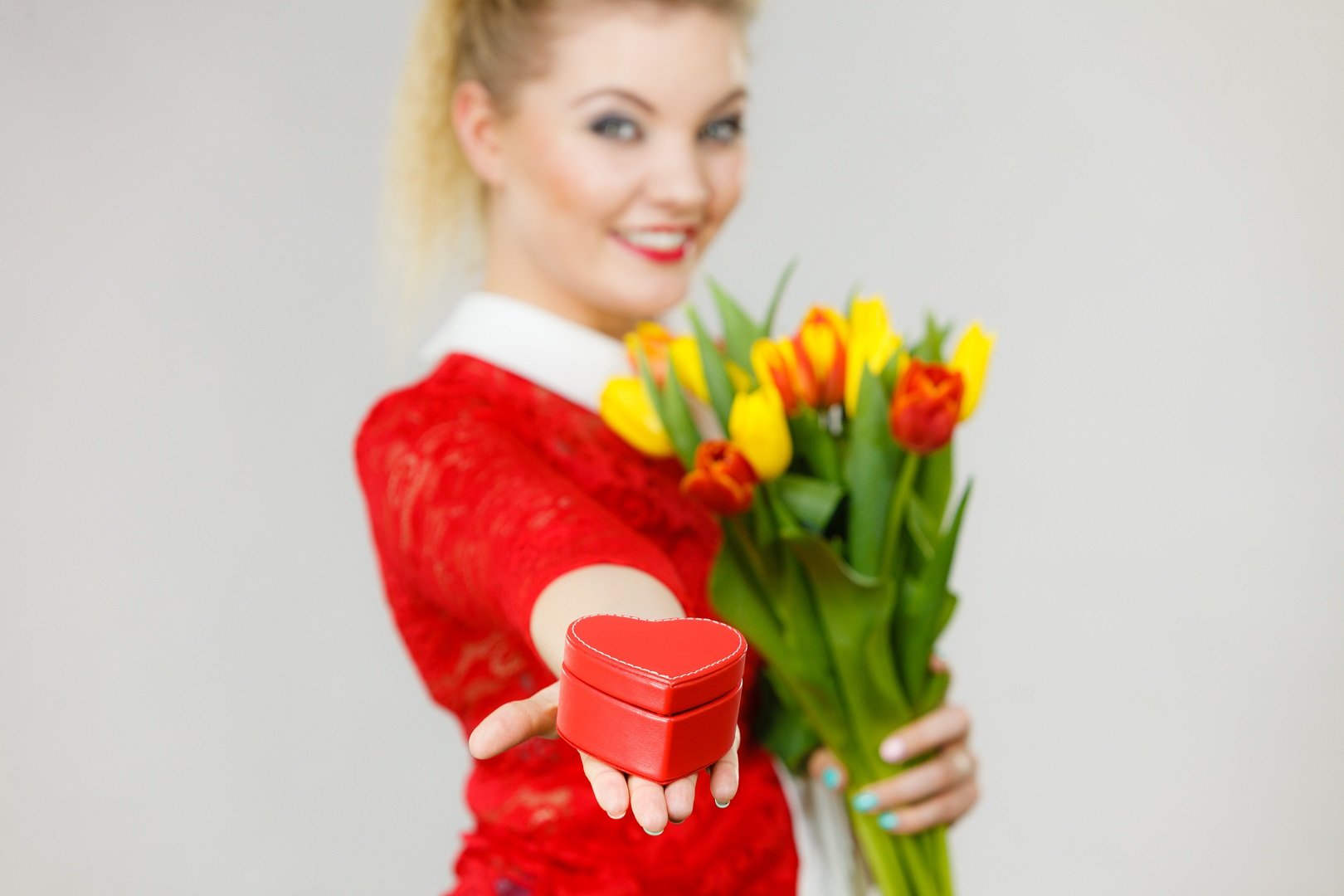 Mujer con flores y regalo || Fuente: Shutterstock Mujer con flores y regalo || Fuente: Shutterstock