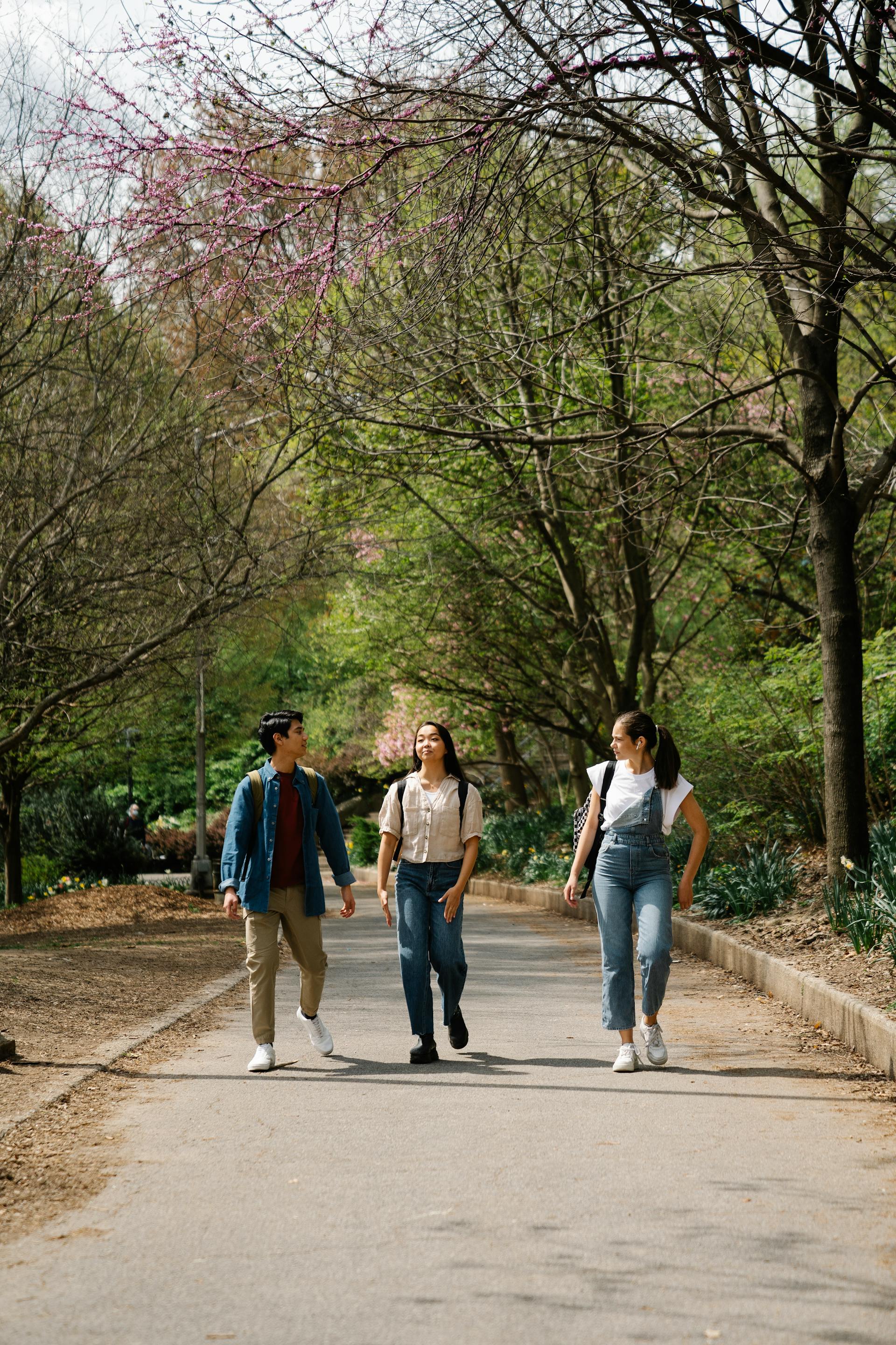 Three young people walking on a pathway | Source: Pexels