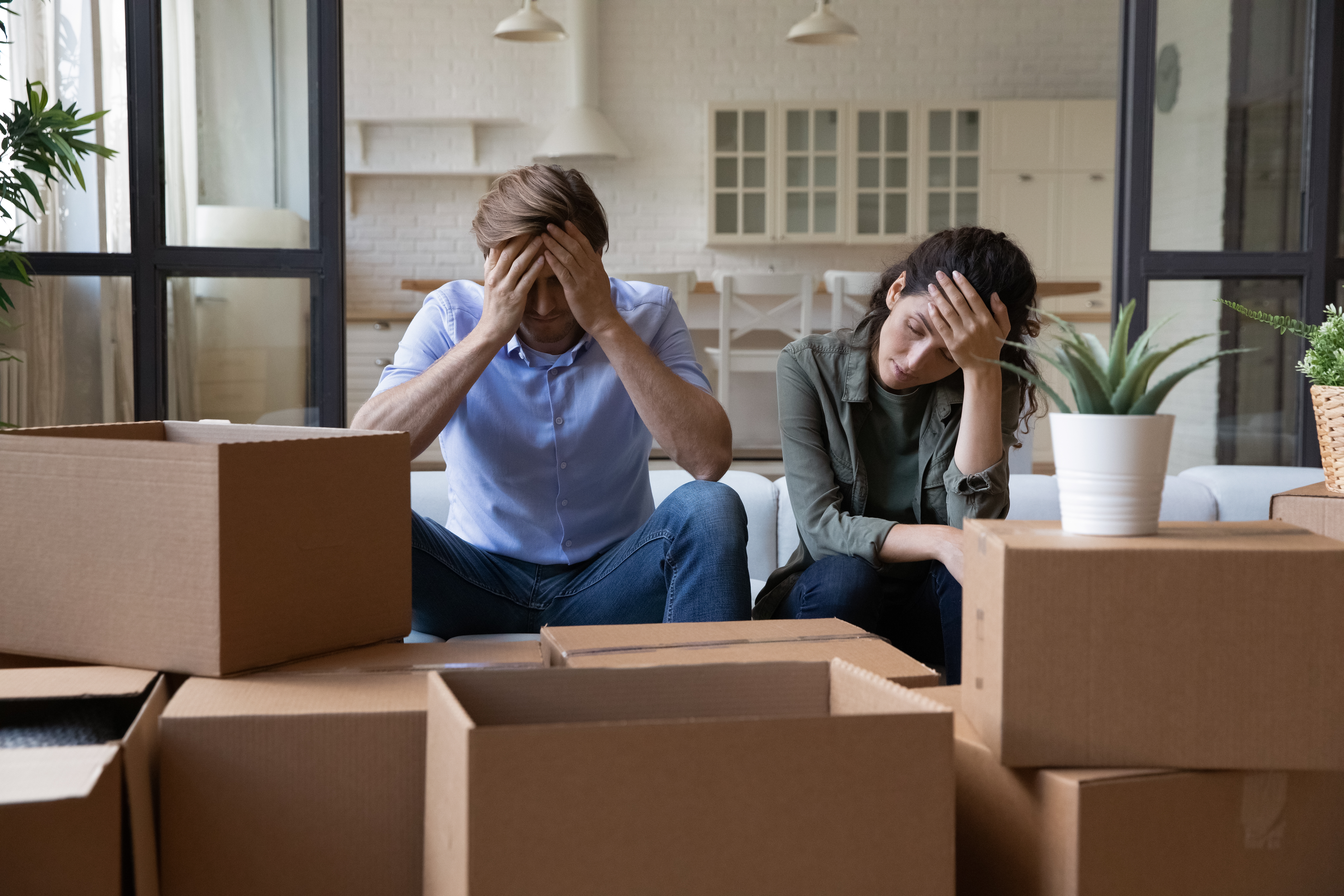 Ein gestresstes Paar umgeben von Kisten | Quelle: Shutterstock
