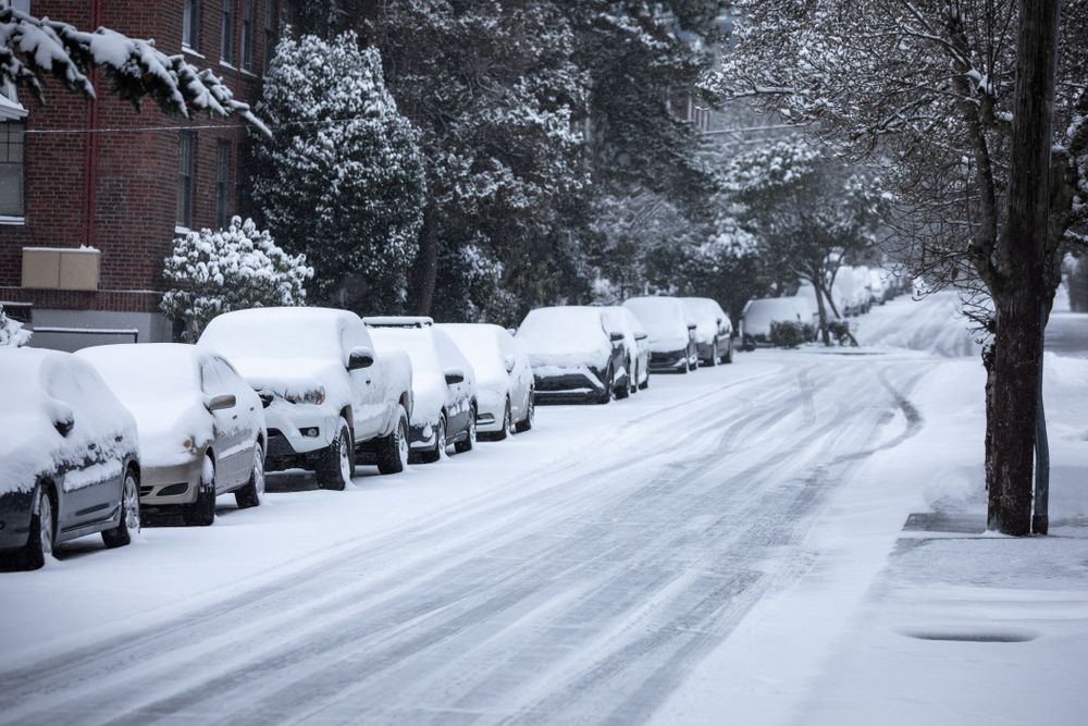A snow covered street filled with snow covered cars. | Source: Shutterstock