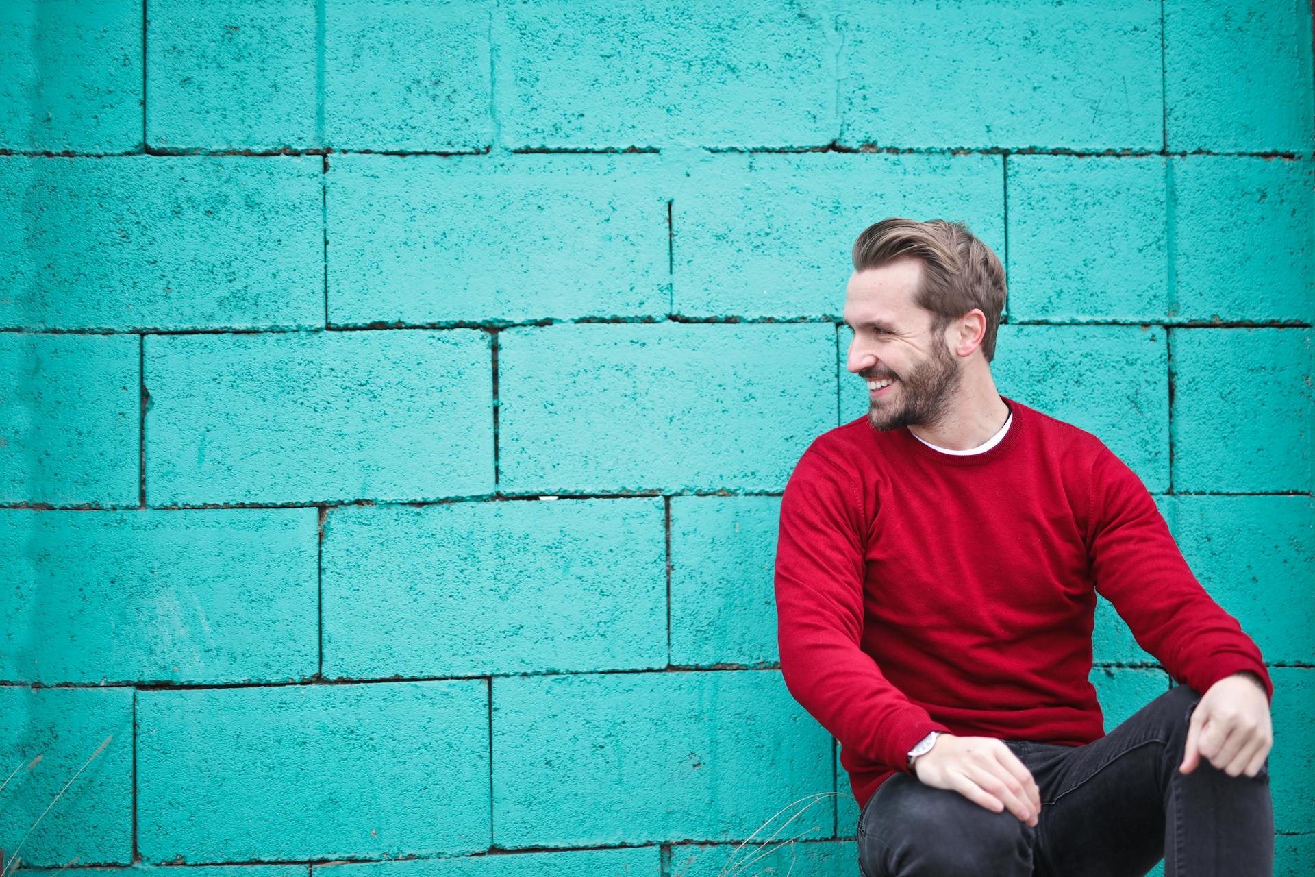 A smiling man leaning against a wall | Source: Pexels
