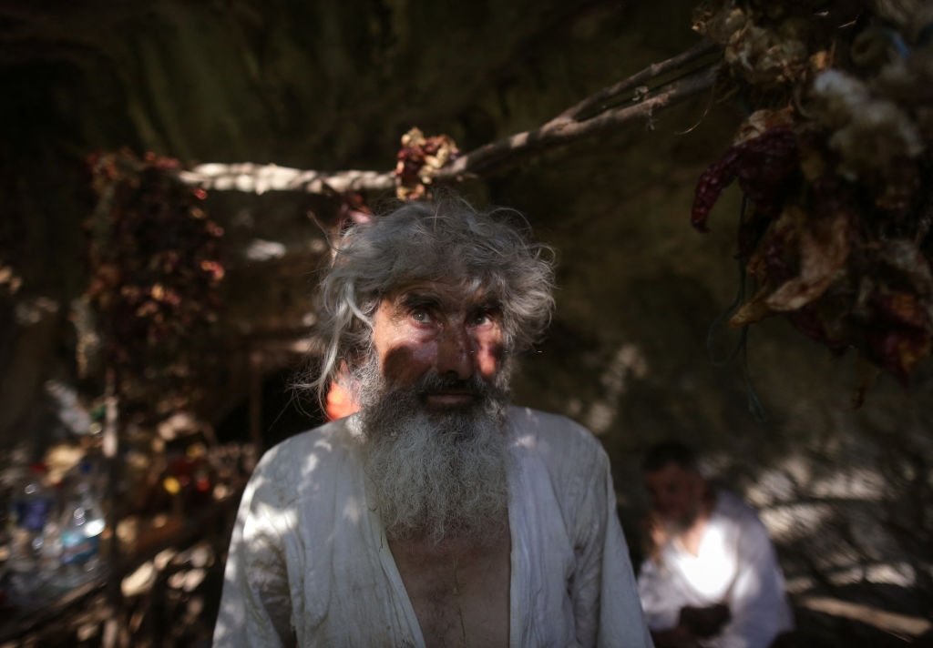 L'ermite serbe Panta Petrovic pose devant sa grotte dans la ville de Pirot, dans le sud de la Serbie, le 9 août 2021. | Photo : Getty Images