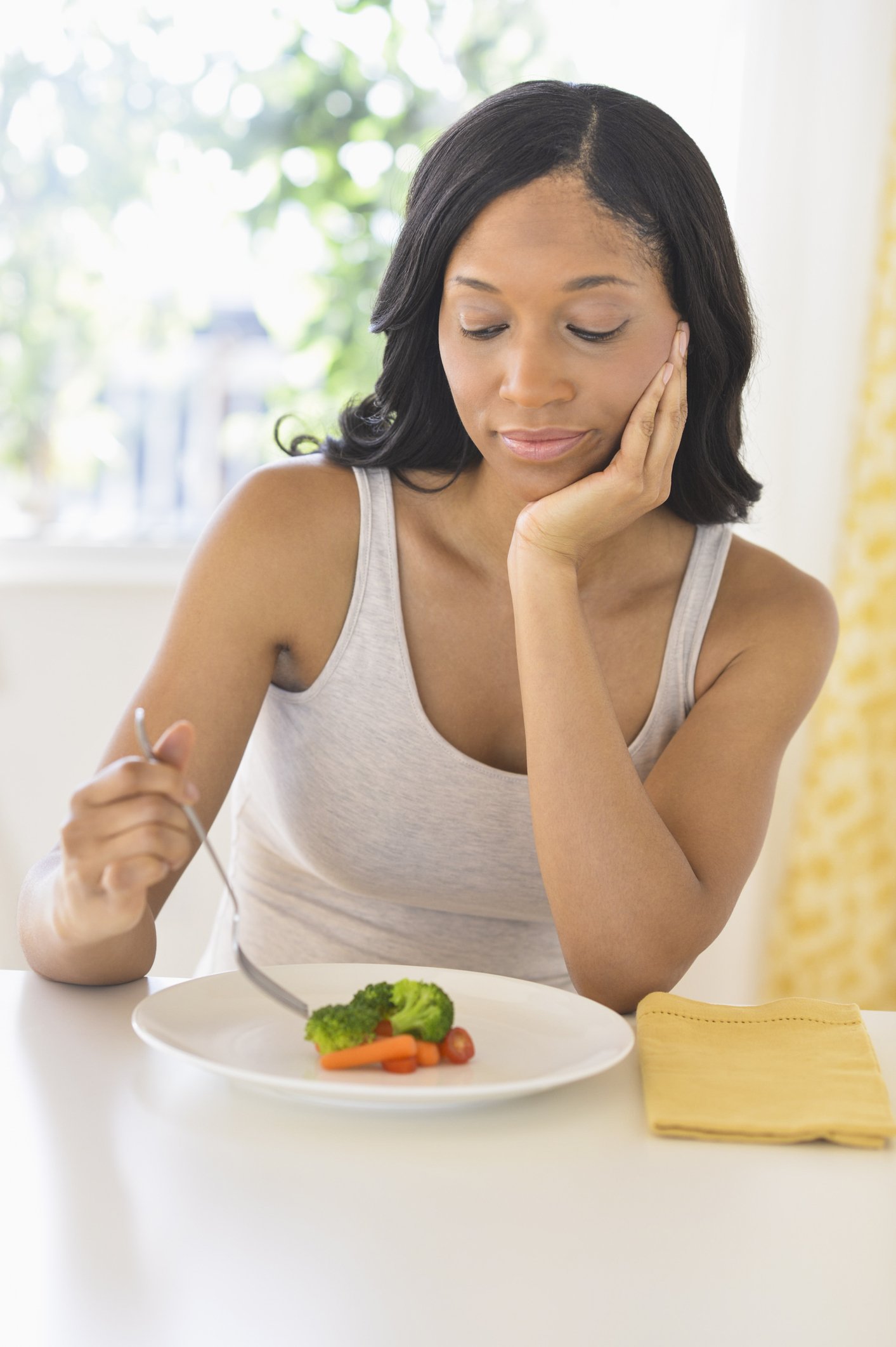 Photo of a young lady eating vegetables | Photo: Getty Images