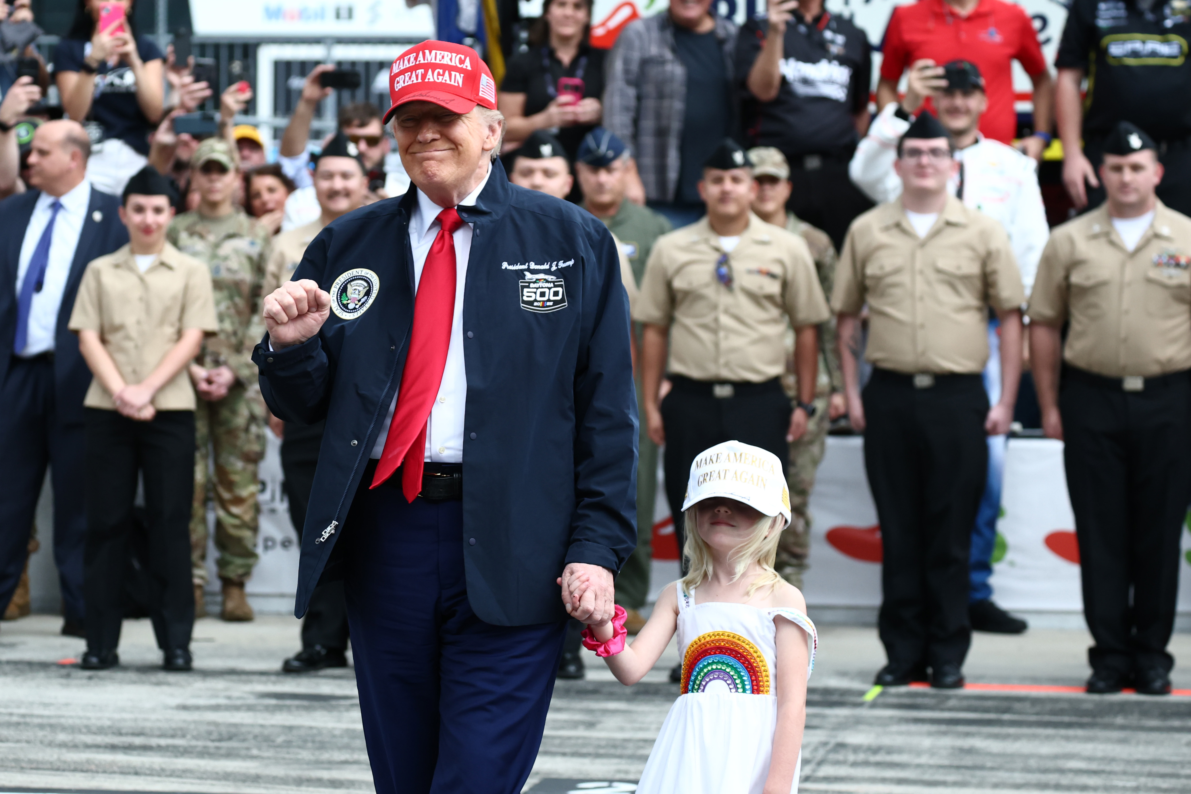 U.S. President Donald Trump and his granddaughter Carolina stand on the grid during pre-race ceremonies prior to the NASCAR Cup Series Daytona 500 at Daytona International Speedway on February 16, 2025, in Daytona Beach, Florida | Source: Getty Images