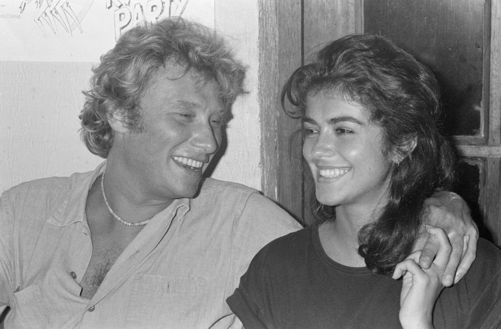 Le chanteur Johnny Hallyday se produit sur la scène du Forest National, à Forest, dans la banlieue sud de Bruxelles, dans le cadre de sa tournée Night Rider Band 1981 avec sa compagne Babeth Etienne | Photo : Getty Images