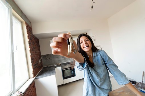 Photo of a happy woman holding keys to her new house | Photo: Getty Images