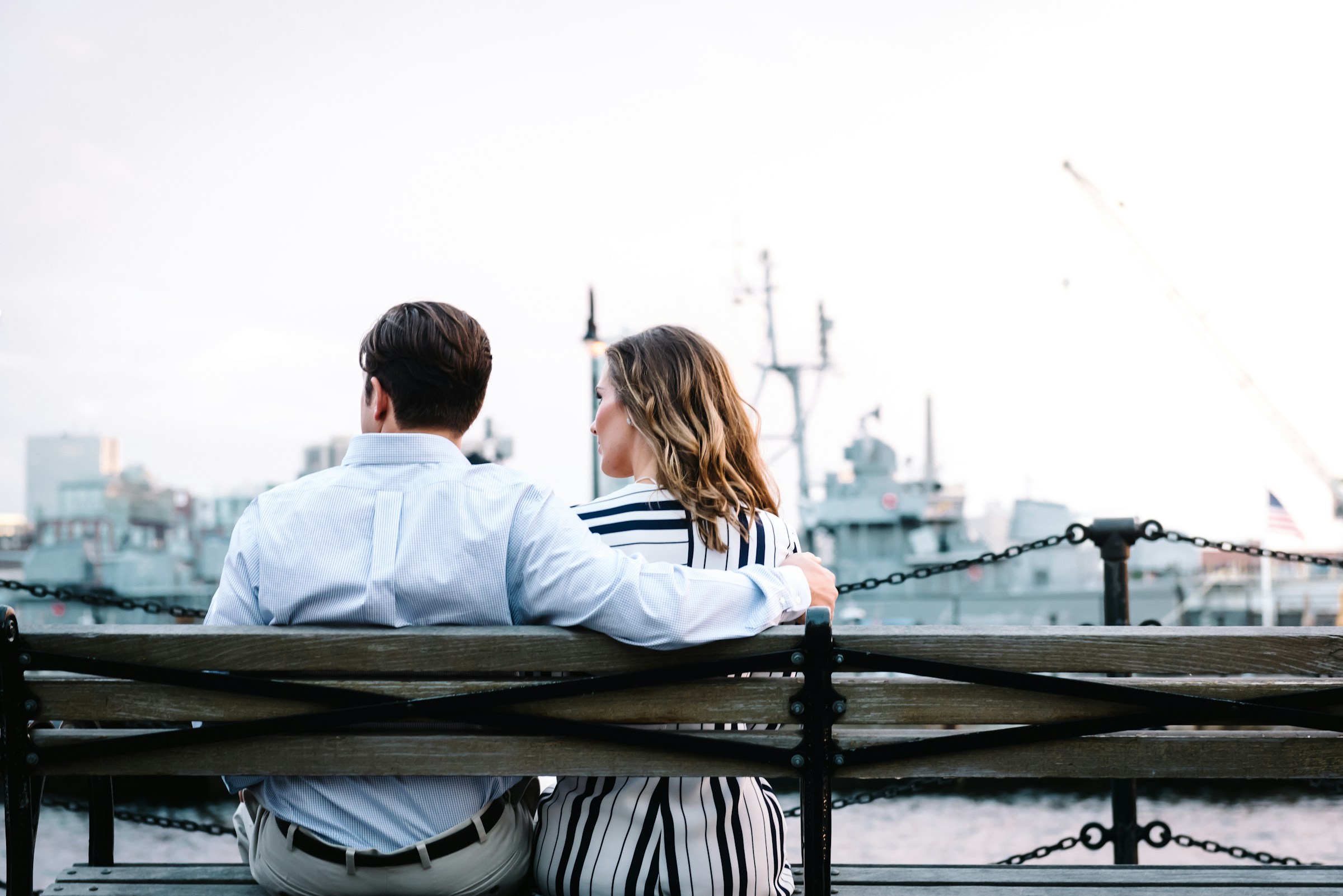 A man embracing a woman as they sit on the bench | Source: Unsplash