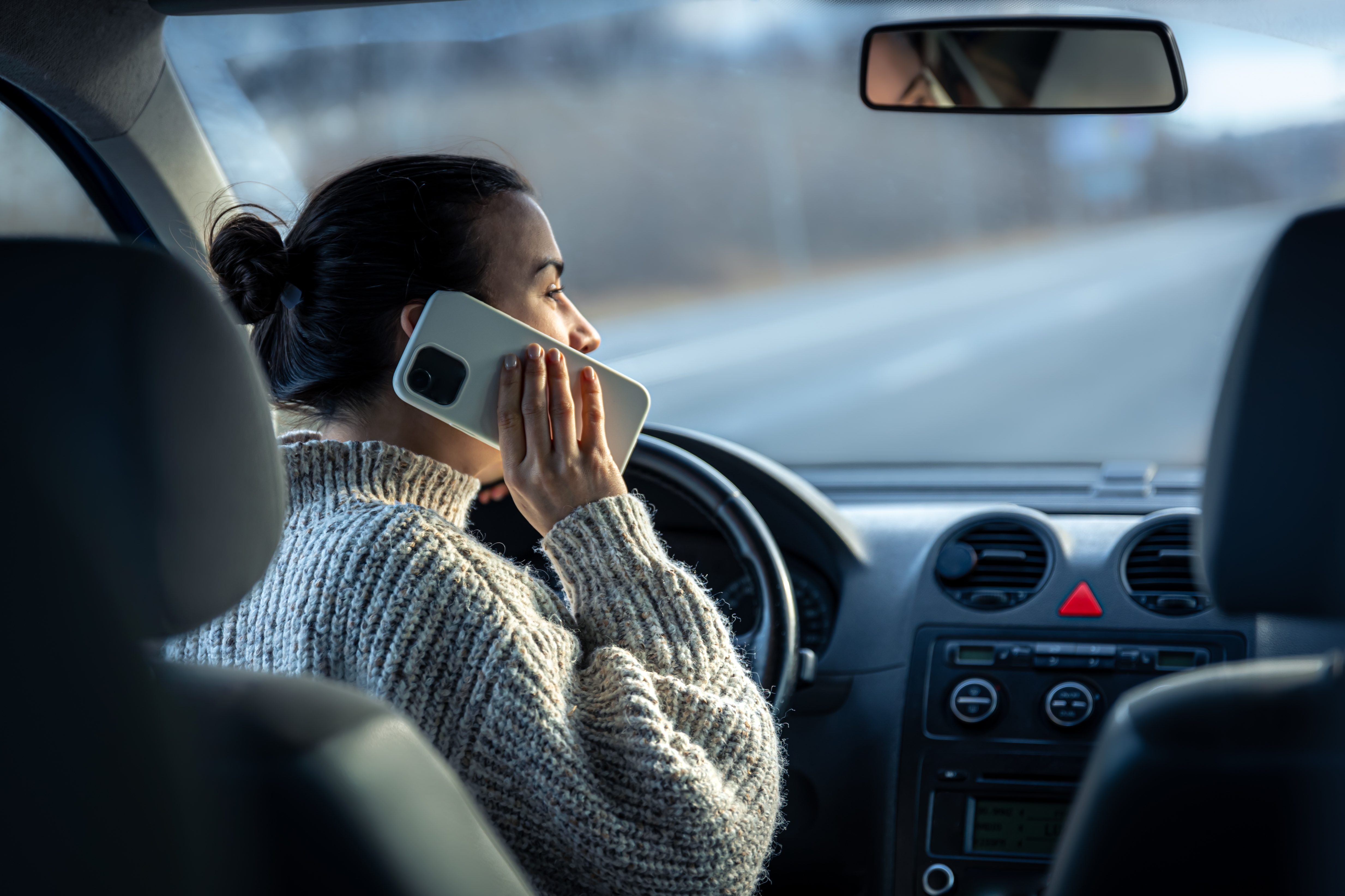 A woman talking on her phone in a car | Source: Shutterstock