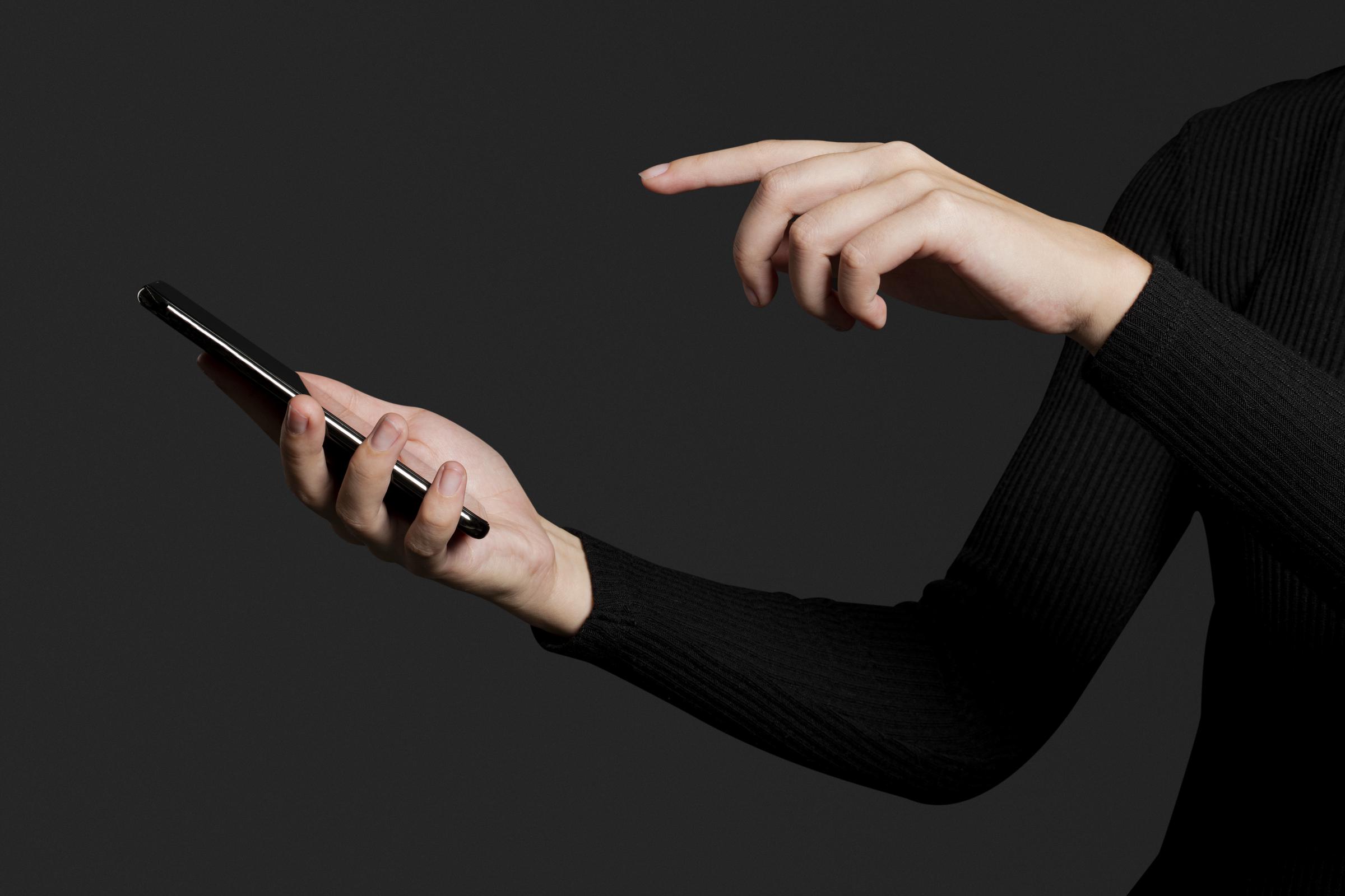 A woman holding a phone | Source: Freepik