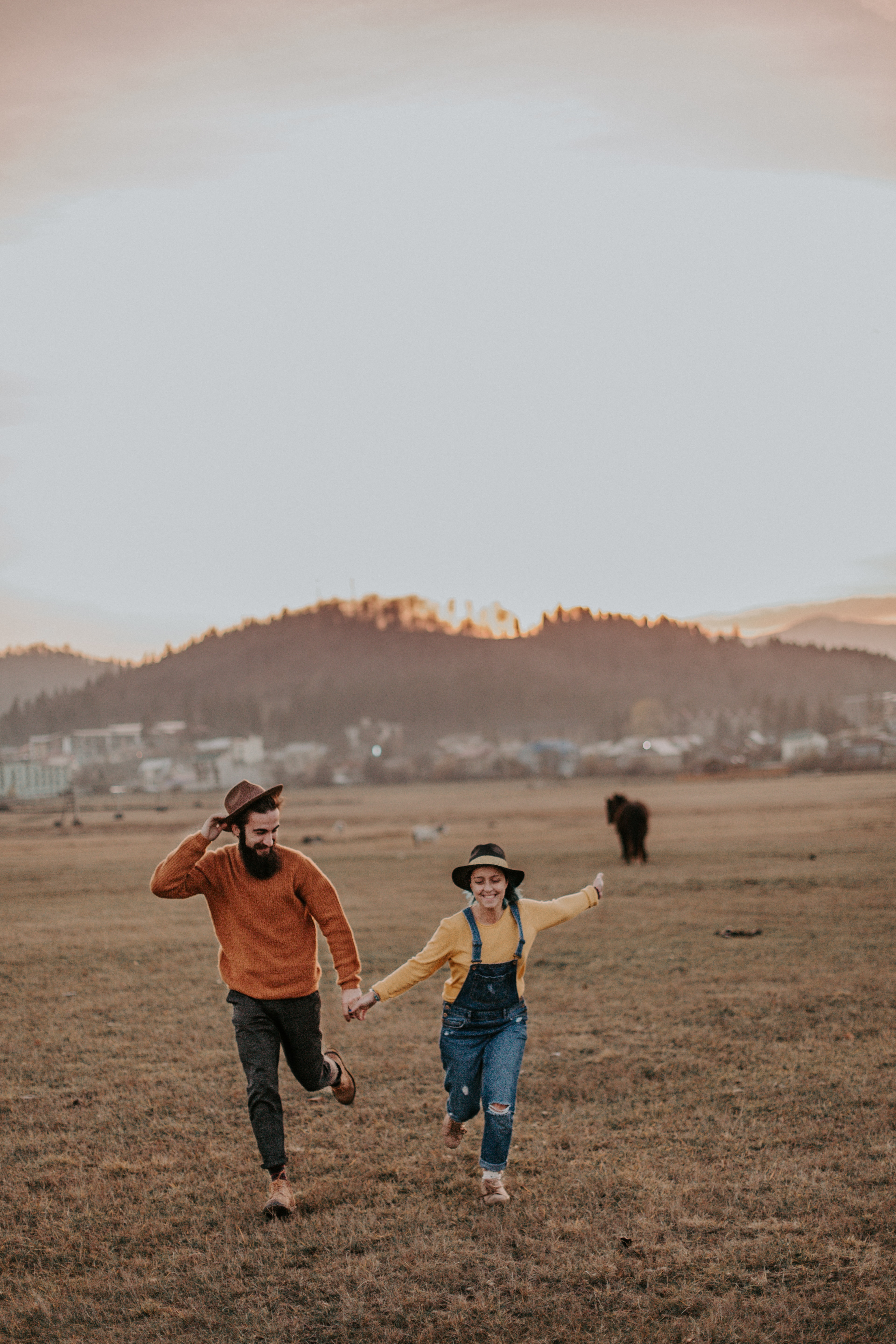 A couple running through a field. | Source: Pexels
