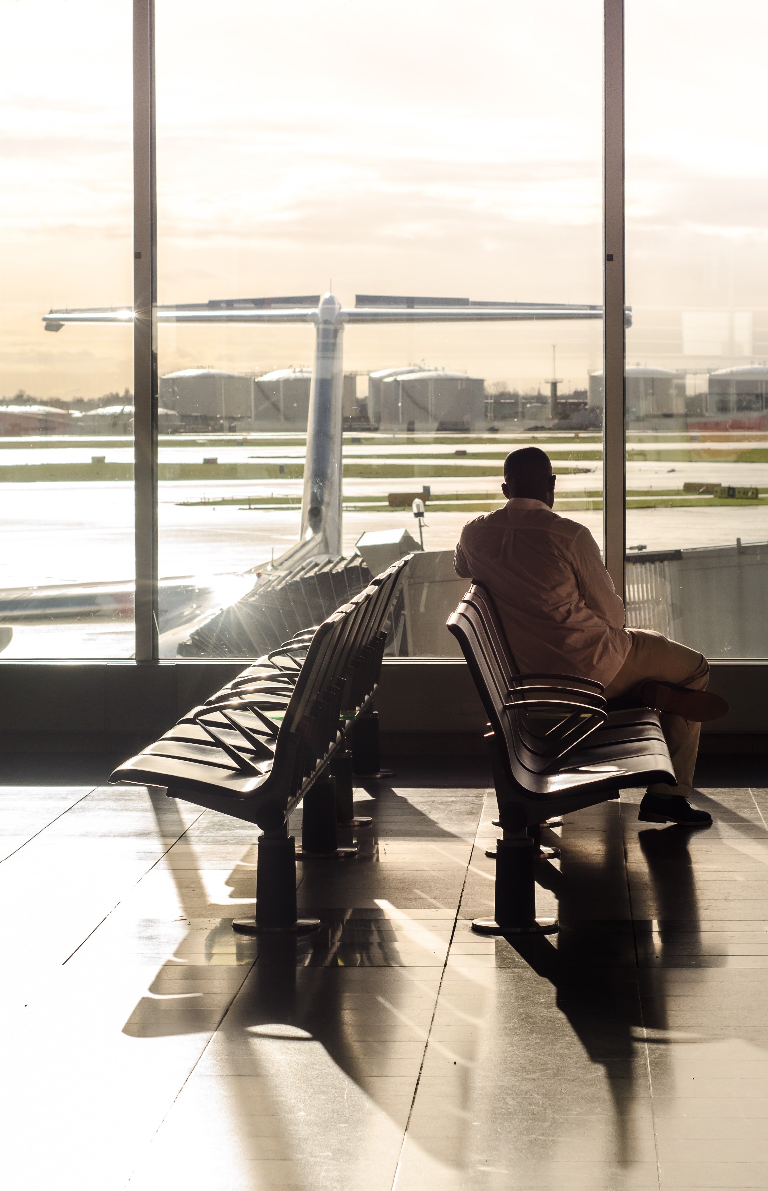 A photo of a man at the airport waiting for his flight. | Photo: Pexels
