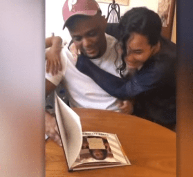 A picture of Alexa Figueroa hugging  Gus Roman as they look through an album| Photo: Youtube/insideedition