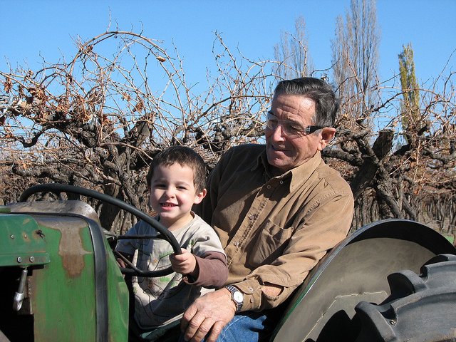 Abuelo paseando con su nieto en un tractor. | Foto: Flickr
