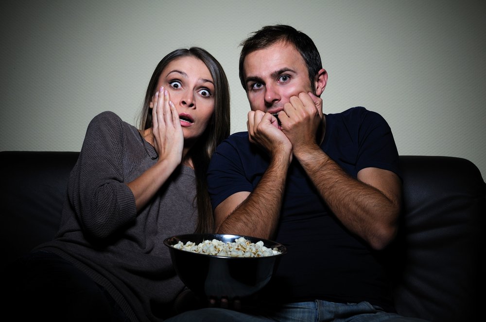Young couple watches scary movie with popcorn | Photo: Shutterstock