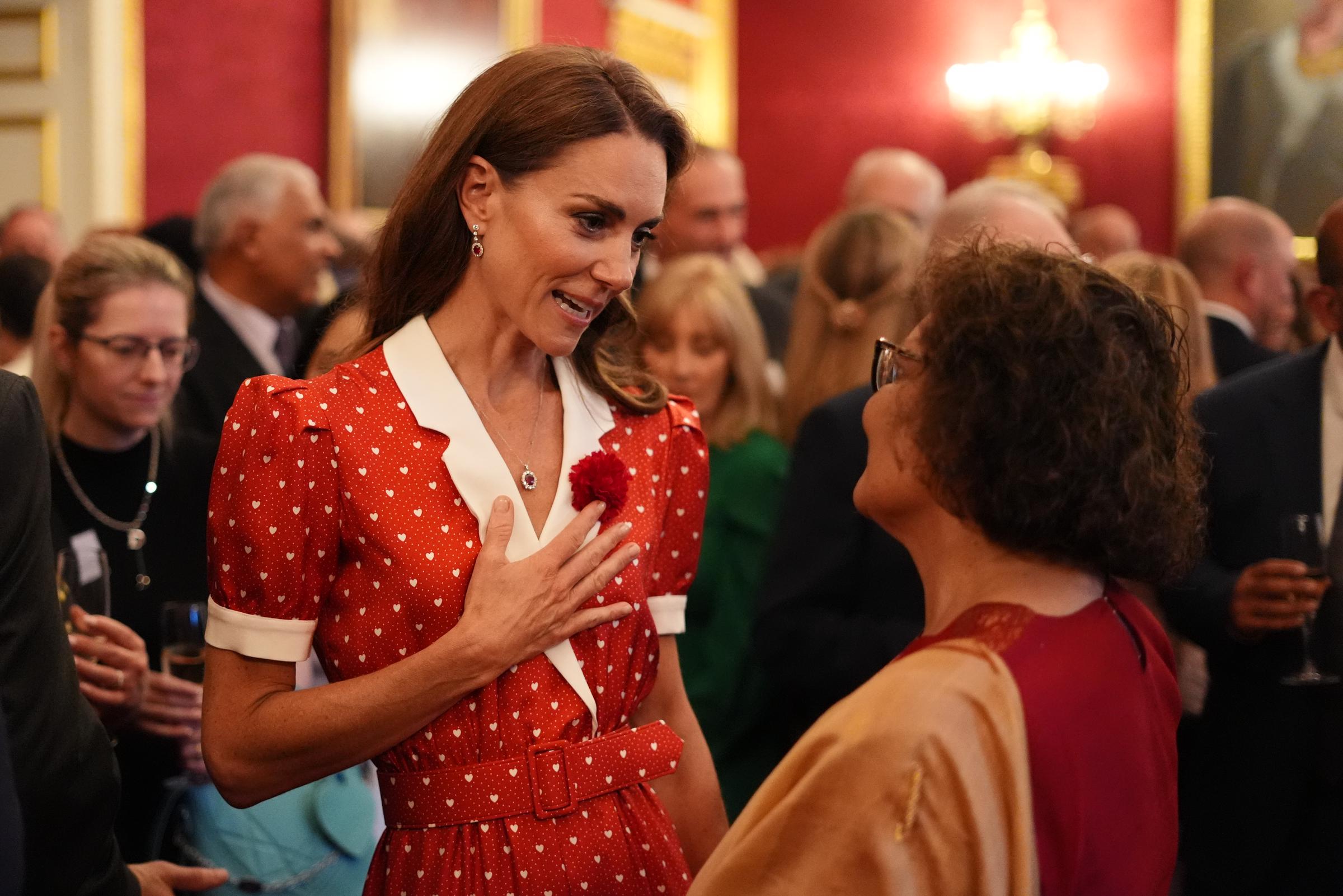Kate Middleton leans into conversation with guests at St. James's Palace, showcasing the personal touch and genuine interest that have become hallmarks of her public engagements.