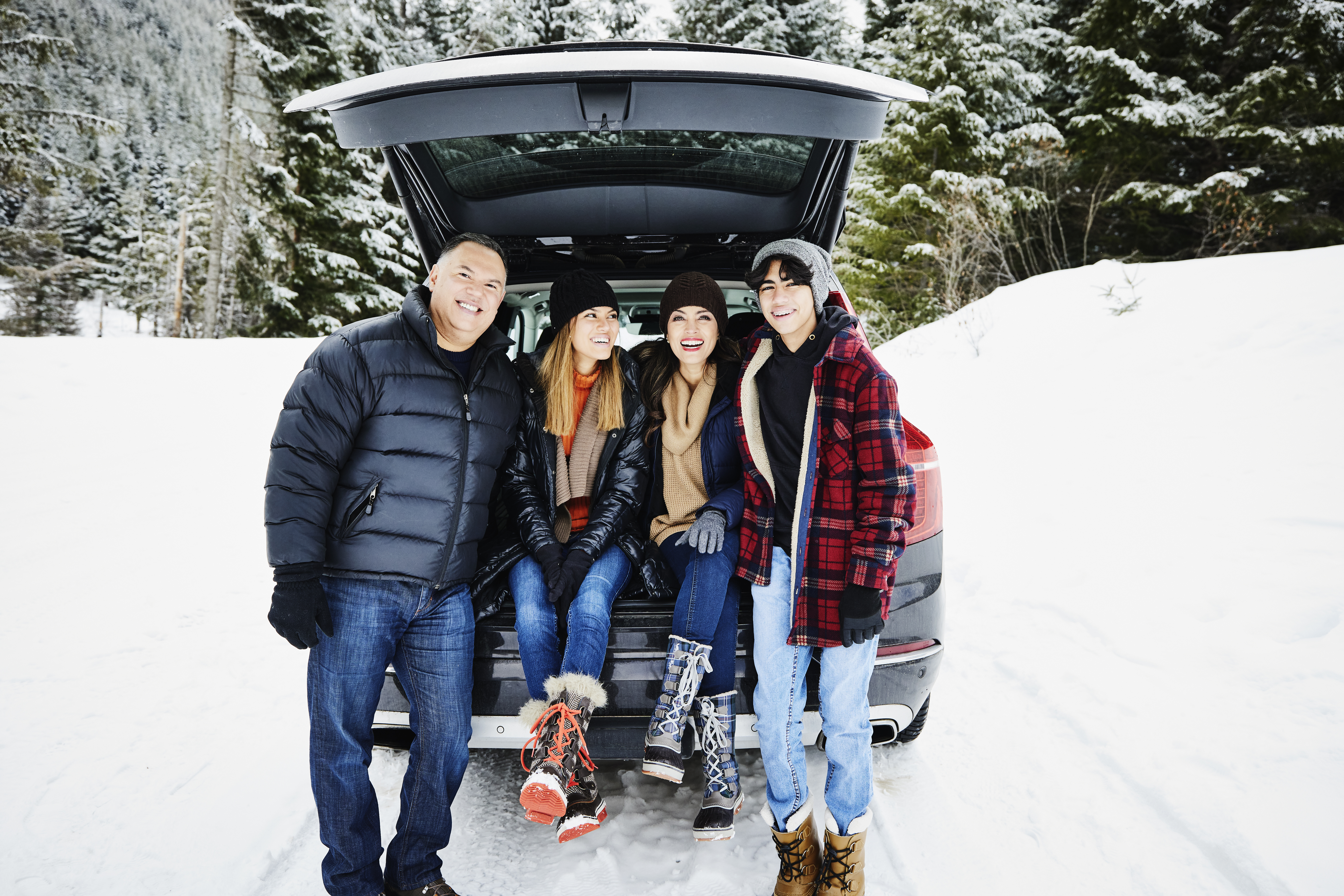 A family sitting in the trunk of their car in the snow | Source: Getty Images