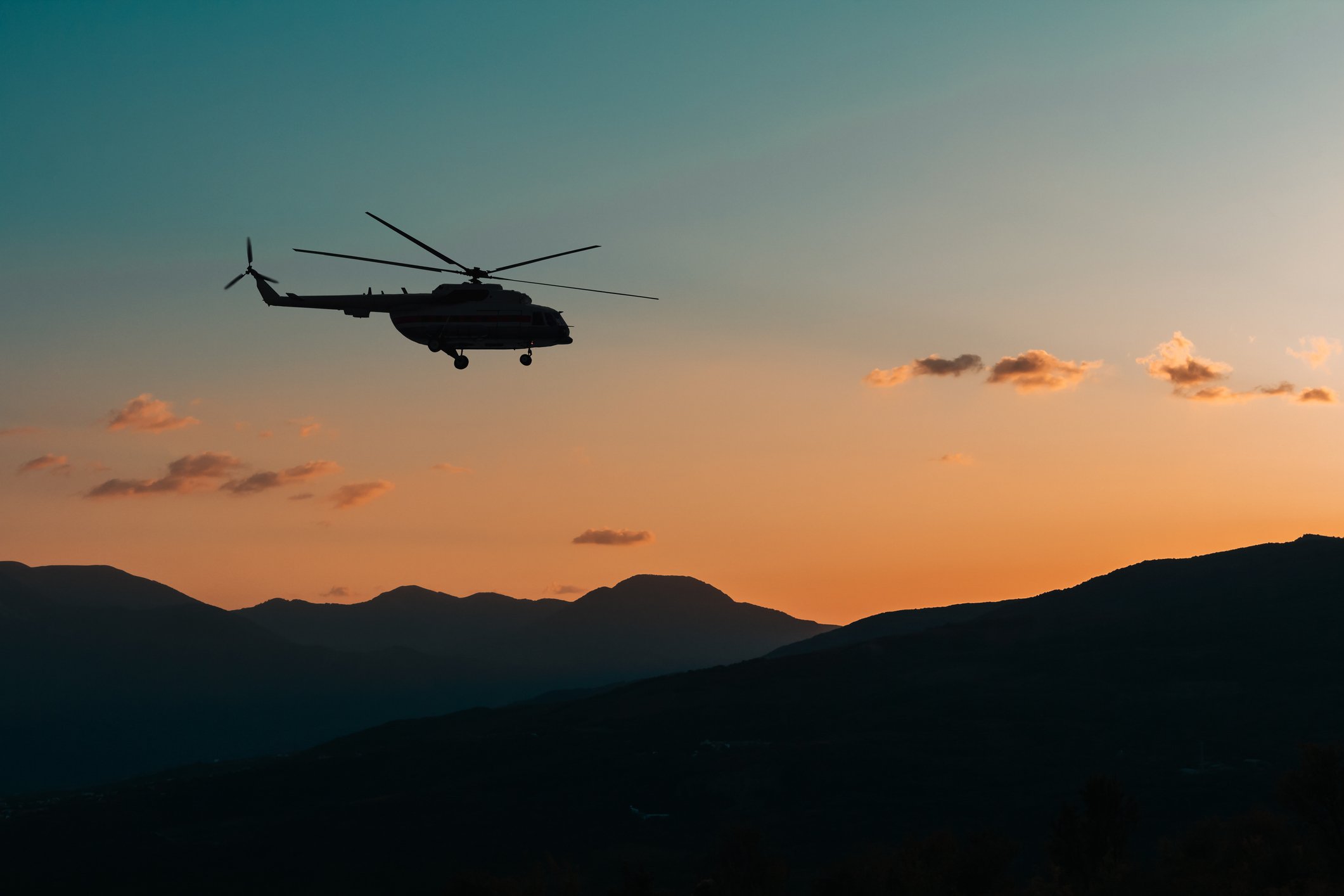 Hubschrauber fliegt in den Bergen bei Sonnenuntergang im Dunkeln I Quelle: Getty Images