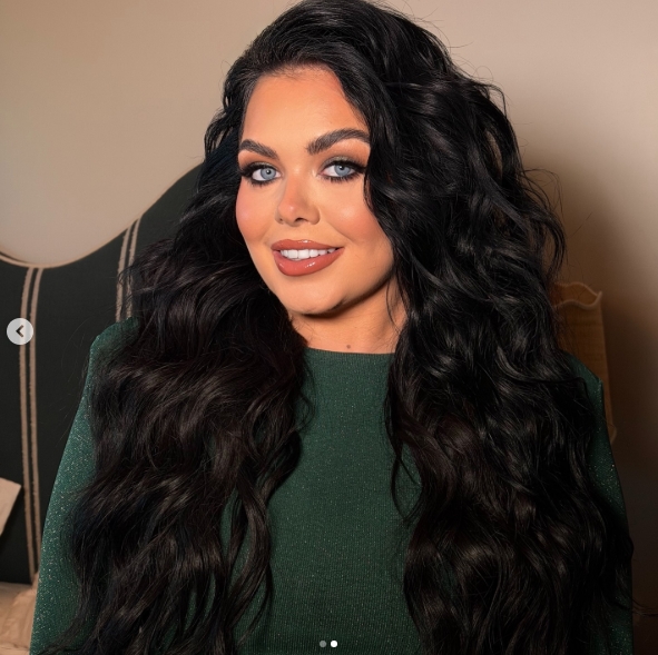 Scarlett Moffatt beamed as she posed for a close-up portrait, highlighting her radiant complexion, defined eye makeup, and long, cascading dark waves styled in loose curls, while wearing a rich-green outfit as she prepared for the "I'm a Celebrity… Get Me Out of Here! South Africa" final on 24 April 2026, capturing a calm yet excited moment ahead of the highly anticipated live show. | Source: Instagram/ scarlettmoffatt