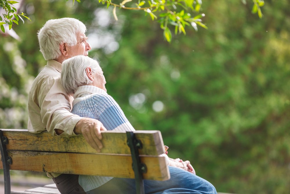 An elderly couple resting on a bench in the park looking at nature. | Photo: Shutterstock.