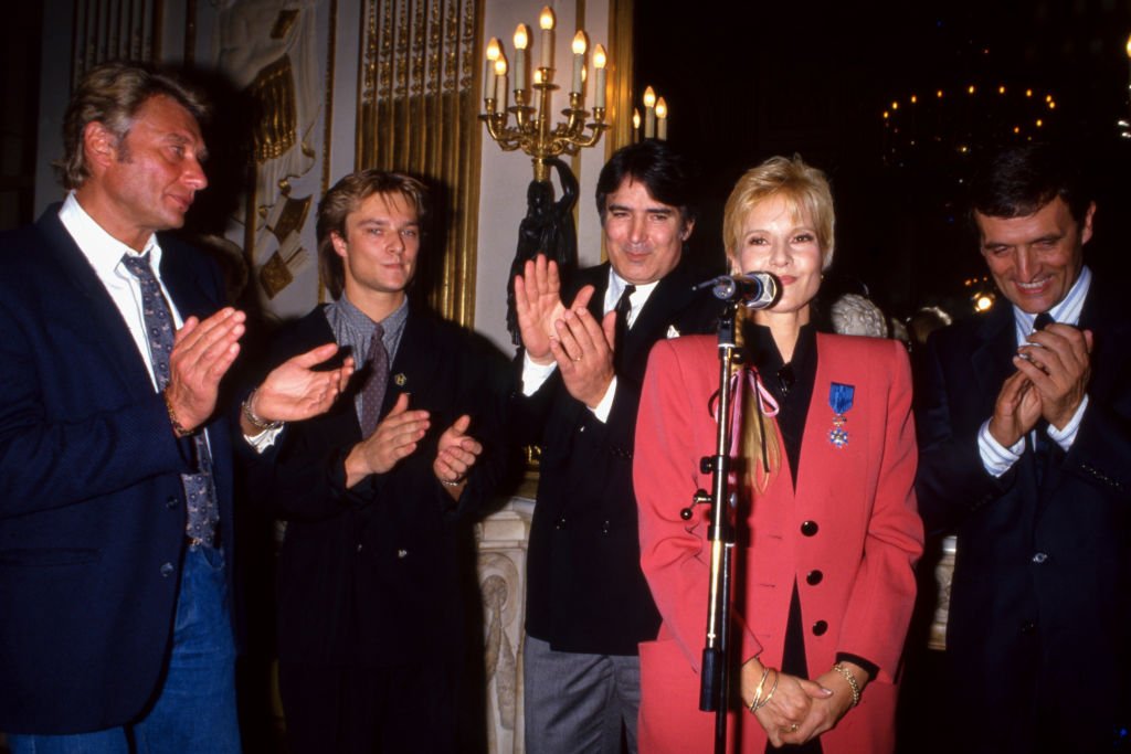 Sylvie Vartan decorated with the National Order of Merit in the presence of Johnny Hallyday, David Hallyday, Tony Scotti and Philippe Léotard on November 13, 1987 in Paris, France.  |  Photo: Getty Images