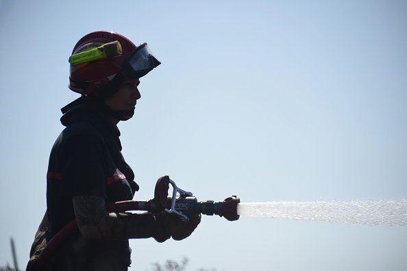 Un pompier pulvérise de l'eau pour éteindre un incendie.| Photo : Getty Images