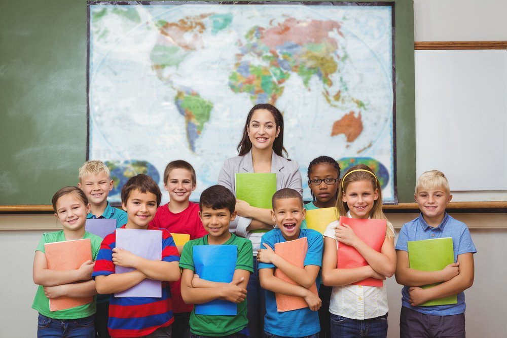 Students standing with the teacher at the elementary school | Photo: Shutterstock