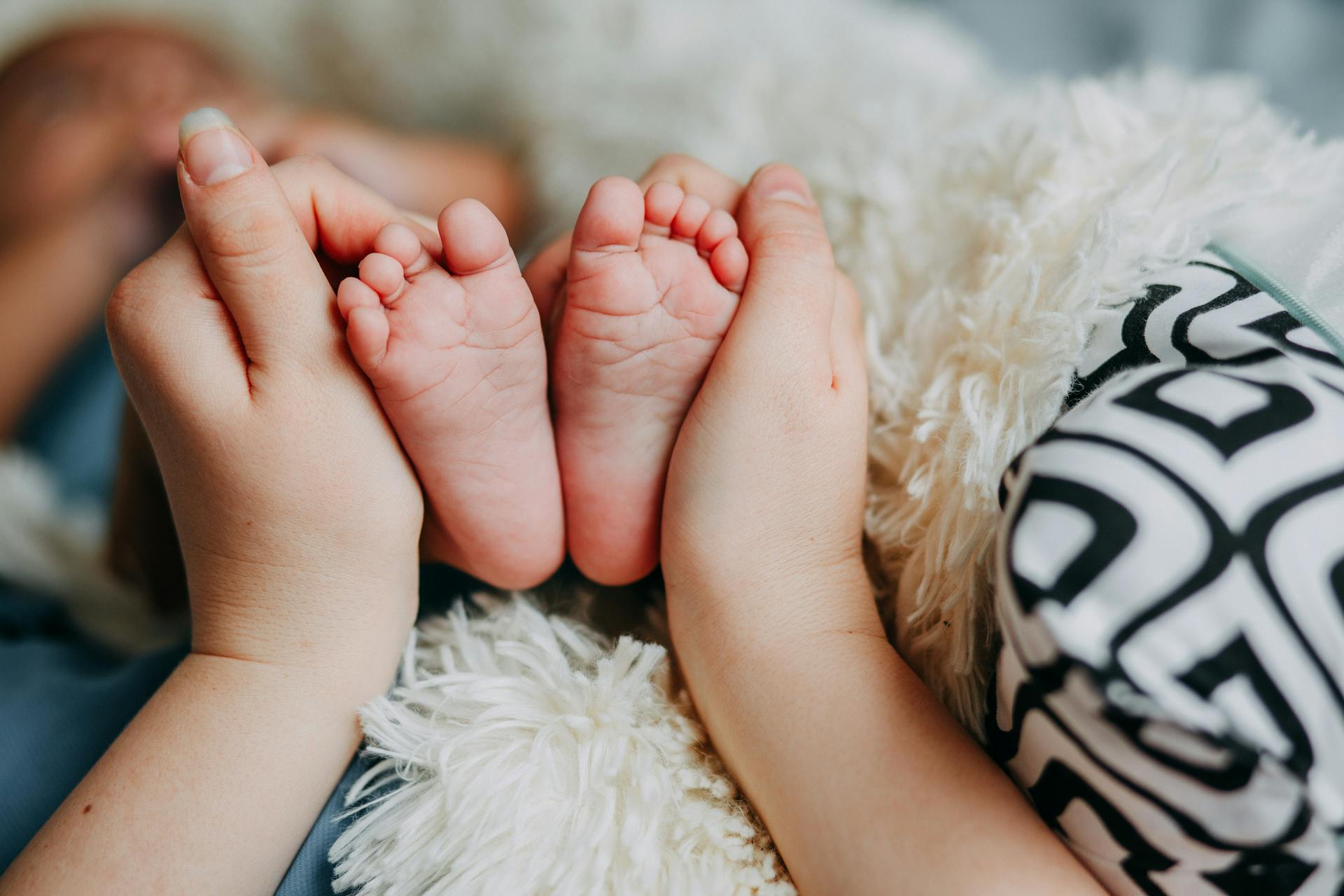 A woman holding her baby's feet | Source: Pexels