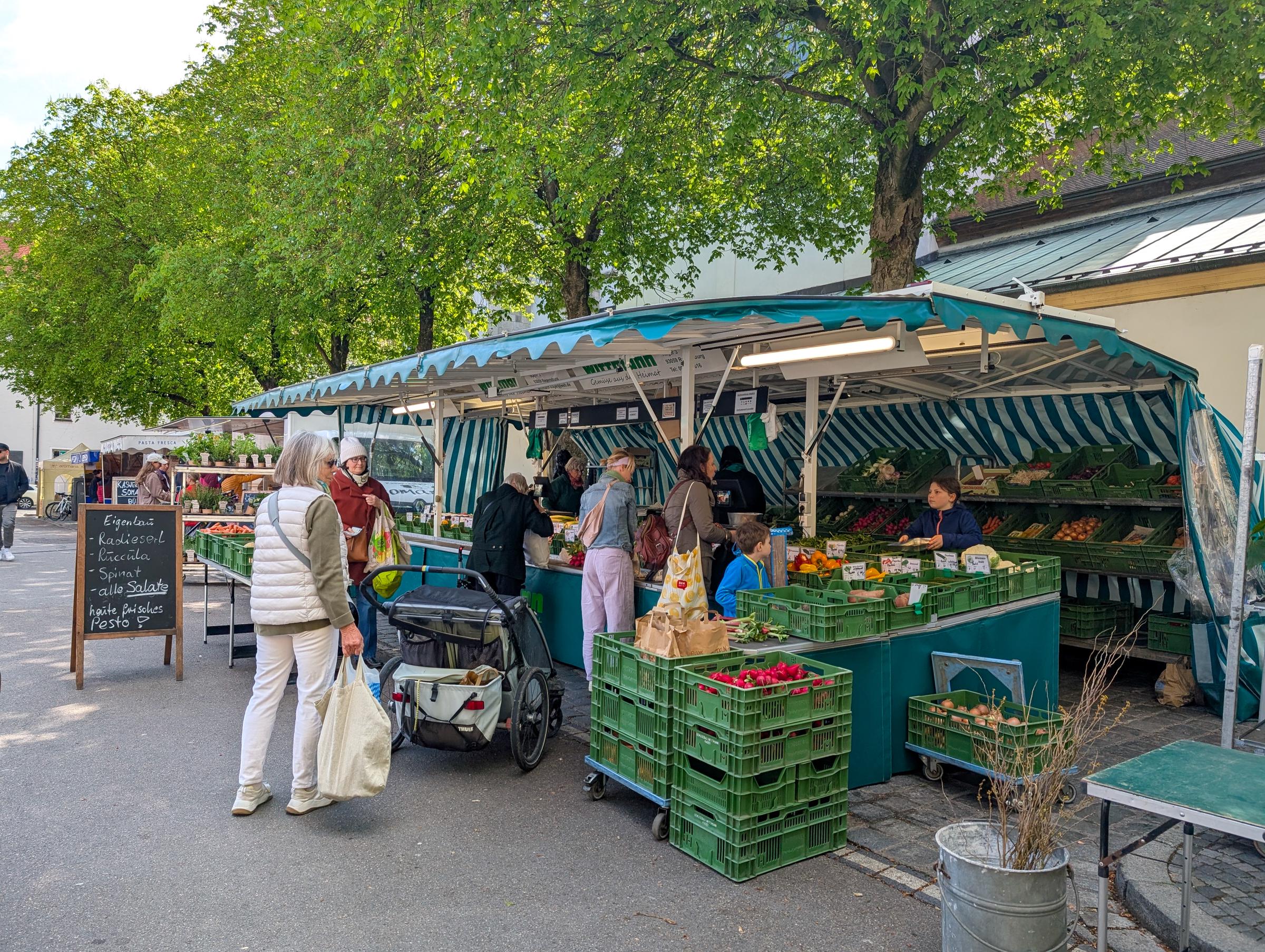Shoppers buy fresh vegetables, fruit, and herbs at an outdoor produce market | Source: Getty Images